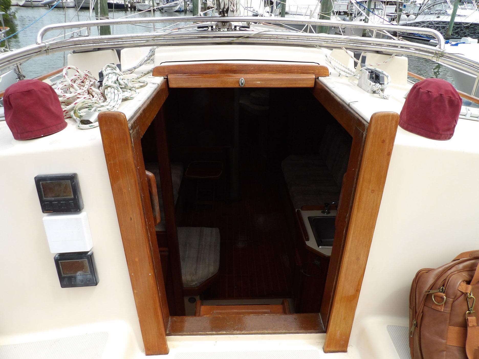 1990 Island Packet 32 sailboat cockpit with open cabin entrance, ropes, and nautical equipment.