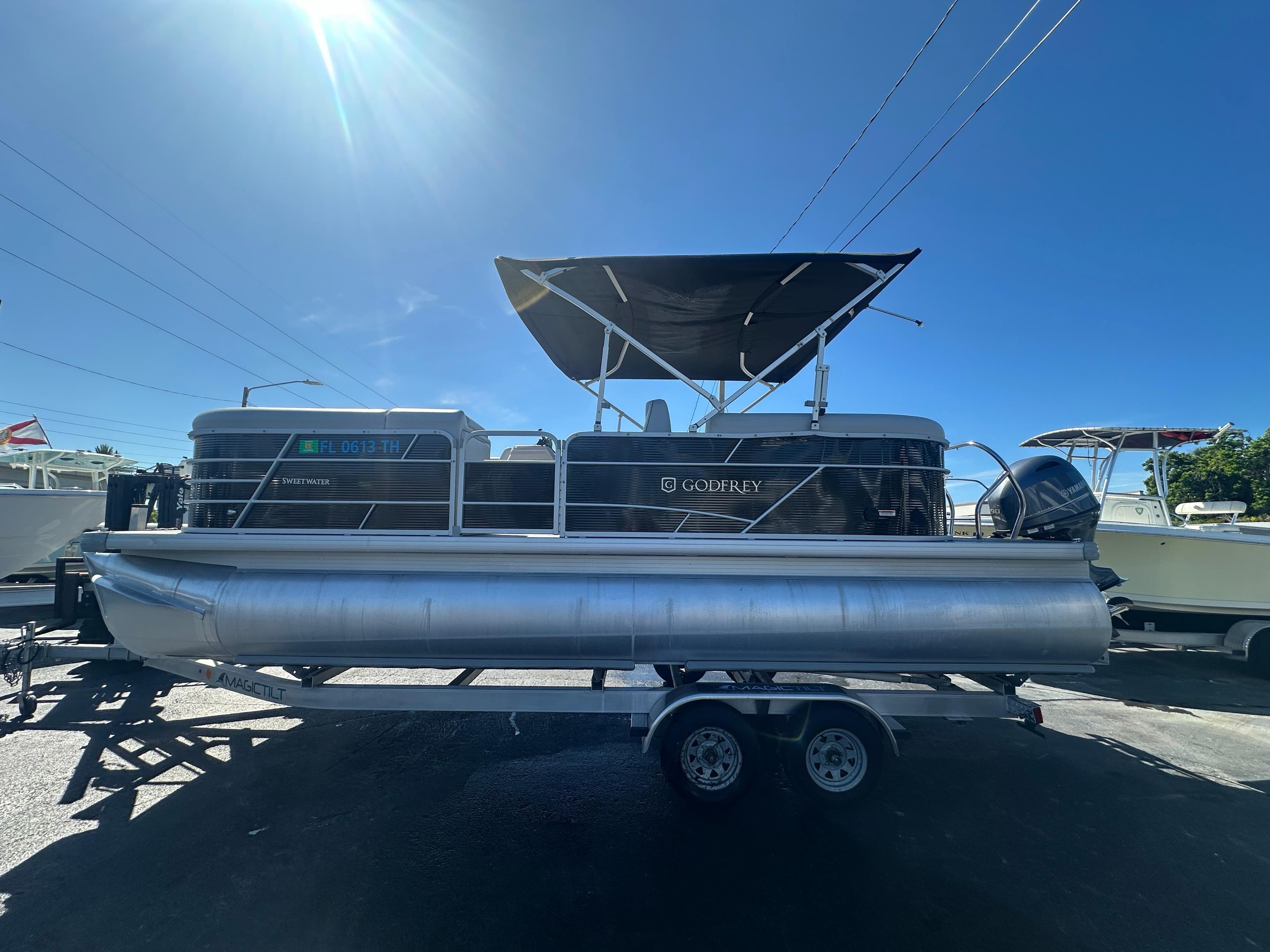 2022 Godfrey Sweetwater 2286 FS pontoon boat on trailer under clear blue sky.
