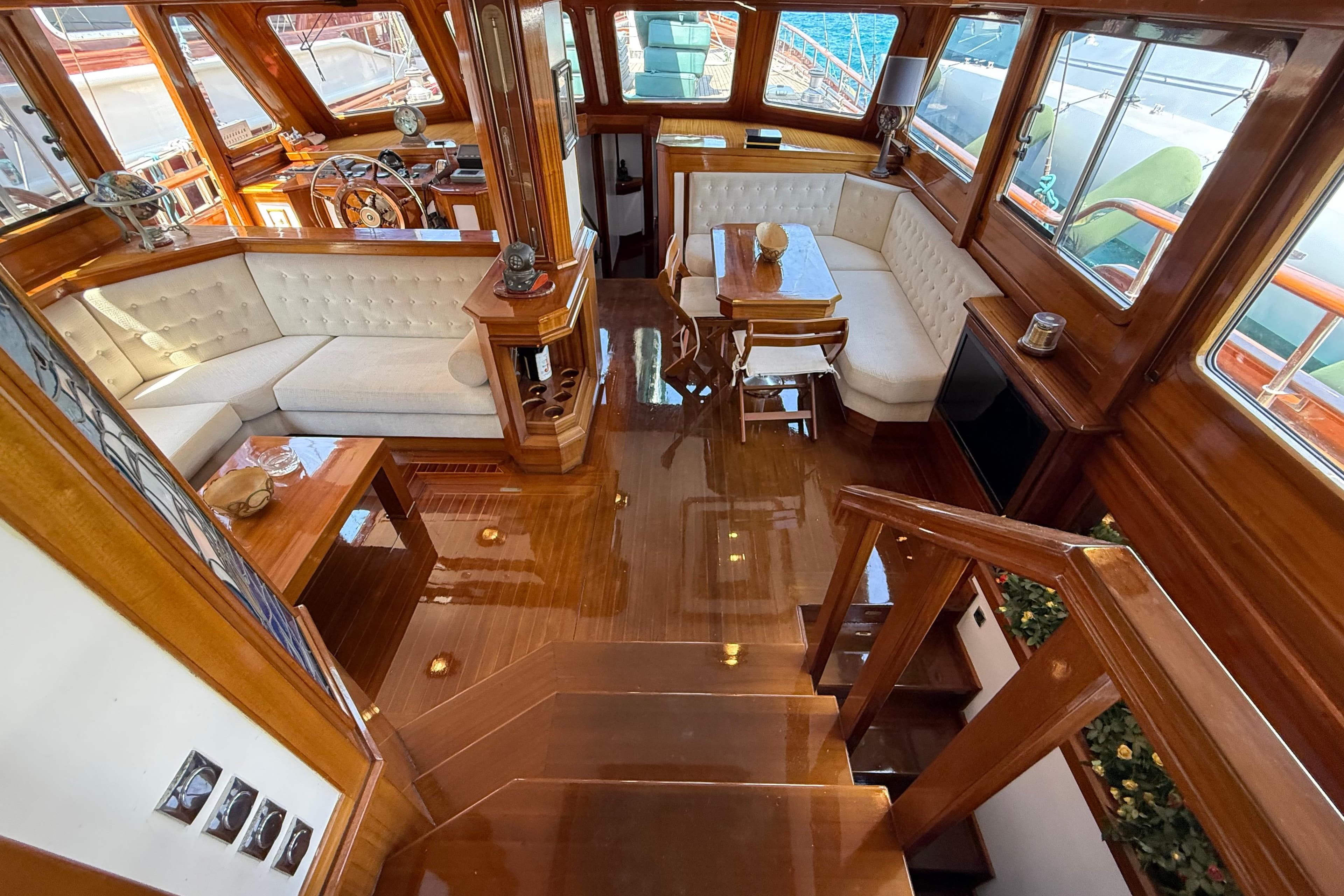 Luxurious interior of a 1999 Mercan 23M yacht with elegant wood finishes and plush seating.