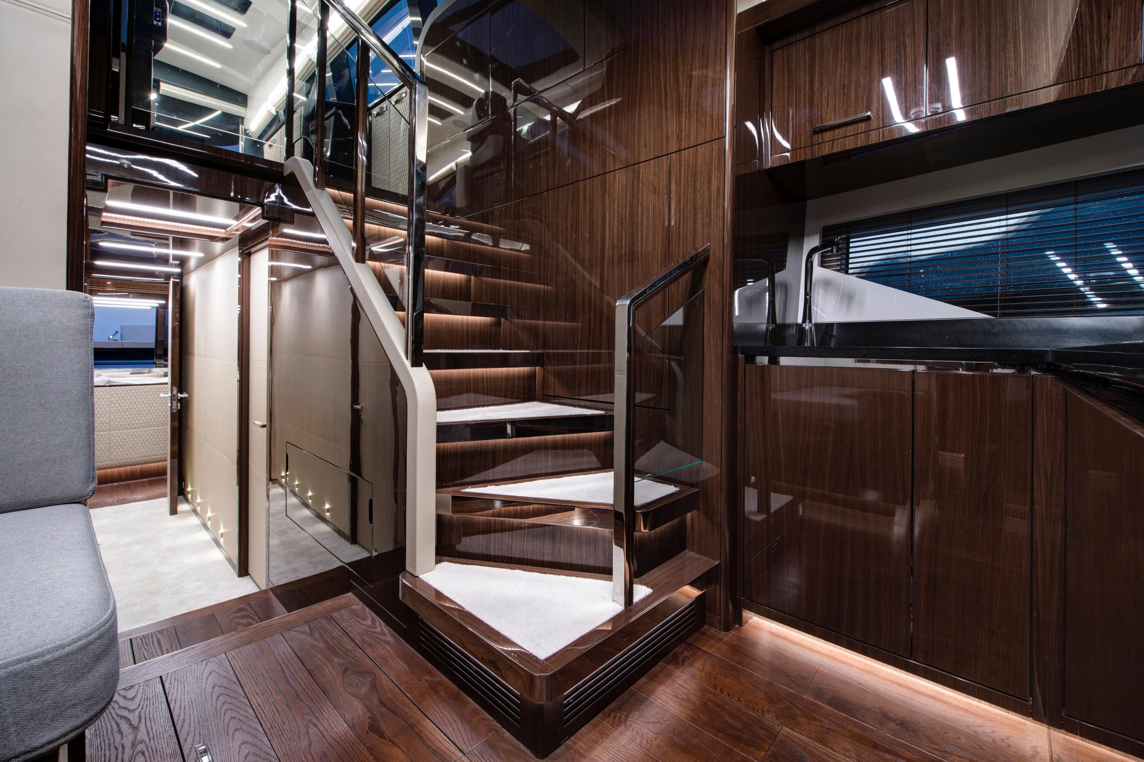 Luxurious interior of 2027 Lazzara LSX 67 yacht with modern staircase and sleek design.