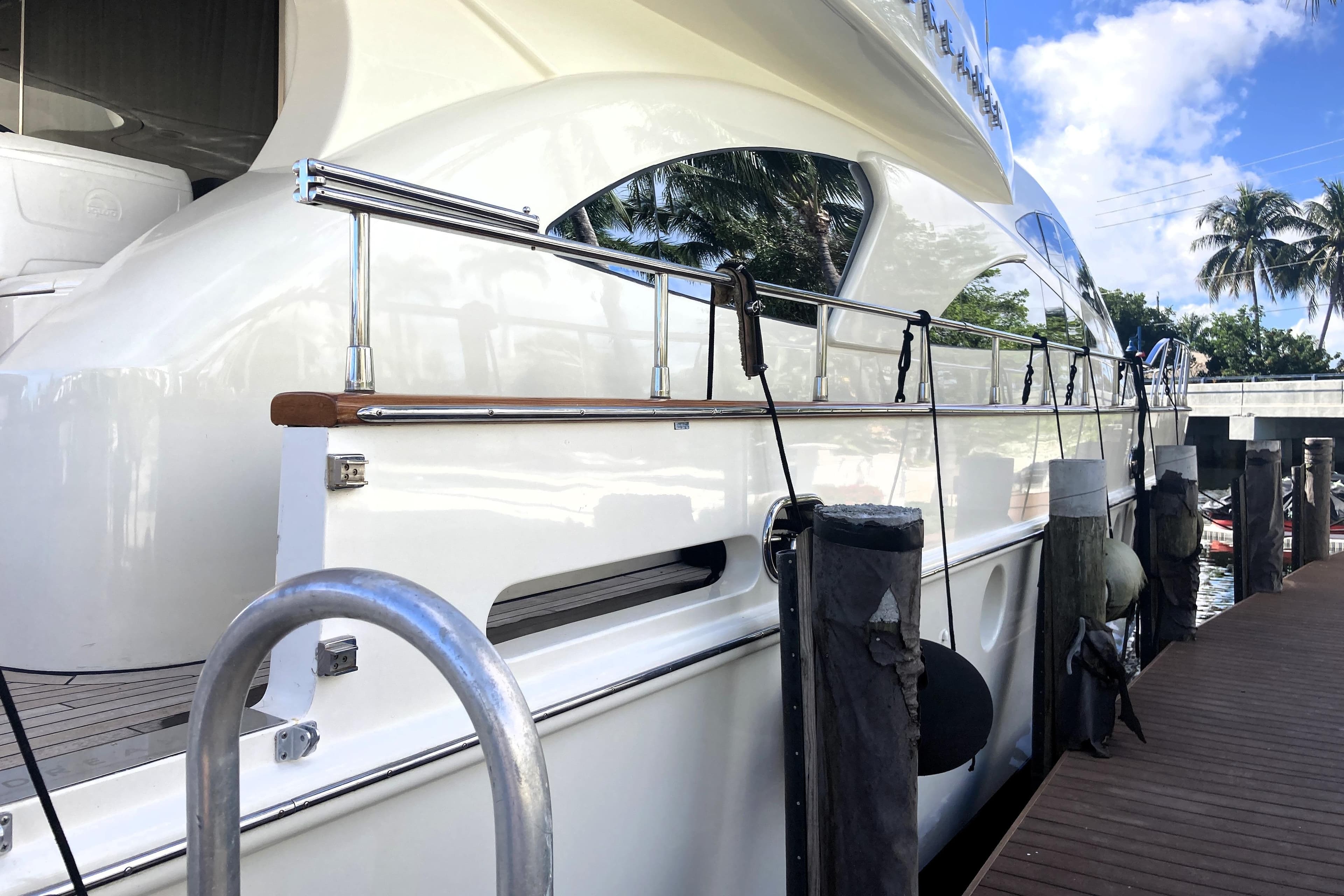 Luxury yacht Azimut 80 Carat 2005 docked, featuring sleek white design and polished railings.