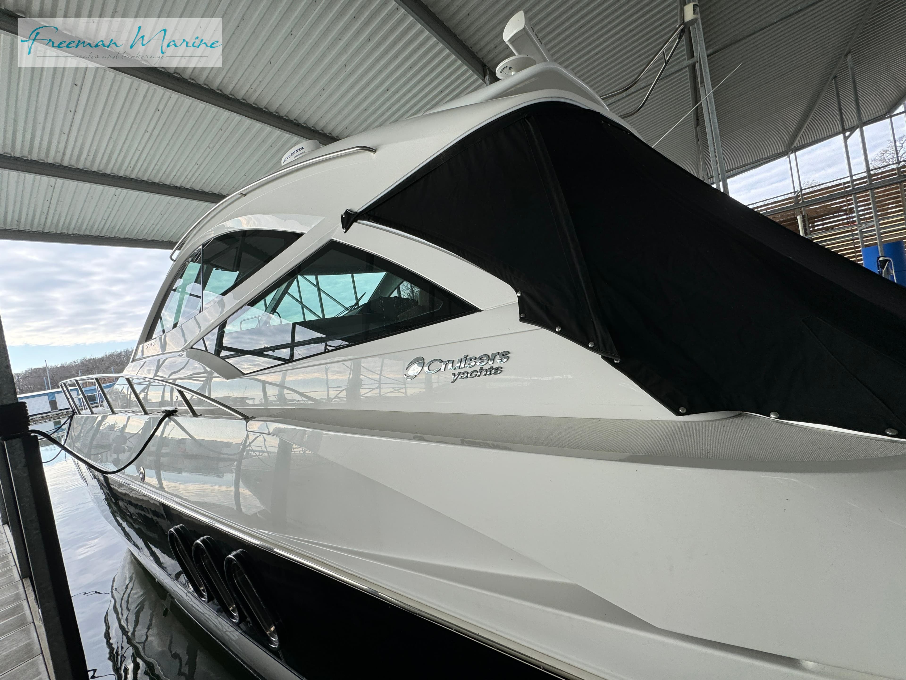 2014 Cruisers Yachts 540 Sports Coupe docked under a covered marina.