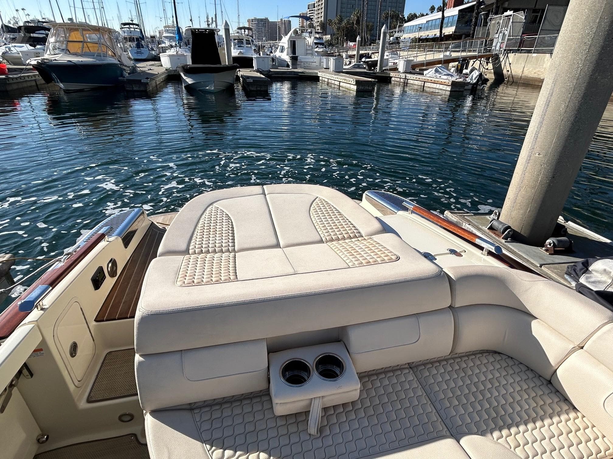 2020 Chris-Craft 25 Launch GT boat interior at marina, featuring luxurious seating and cup holders.