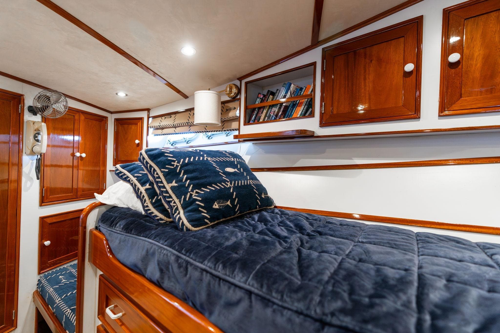 Luxurious cabin interior of 1965 De Vries Lentsch 64 Motoryacht with wooden finishes and cozy bedding.