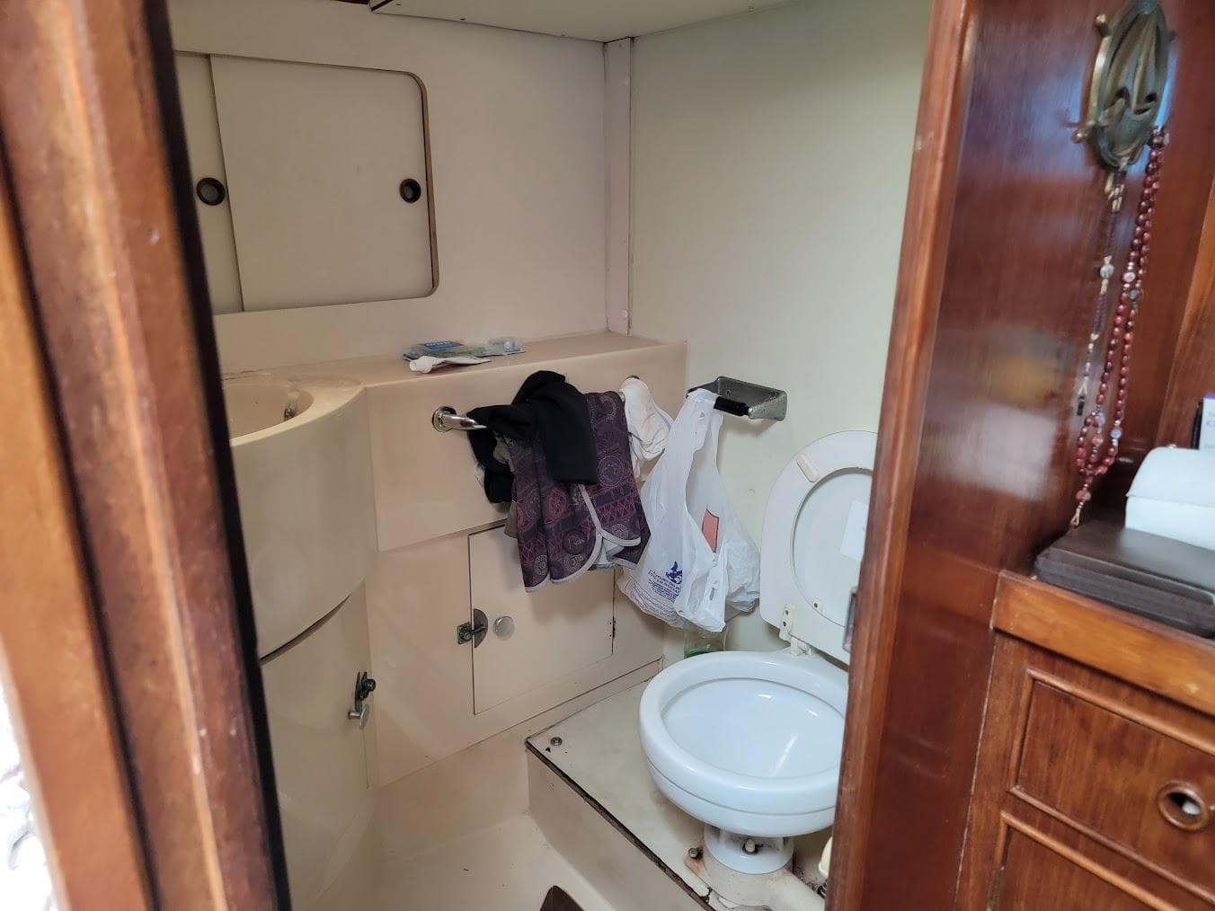 Small bathroom in a 1984 Moody 419 sailboat with toilet and sink.