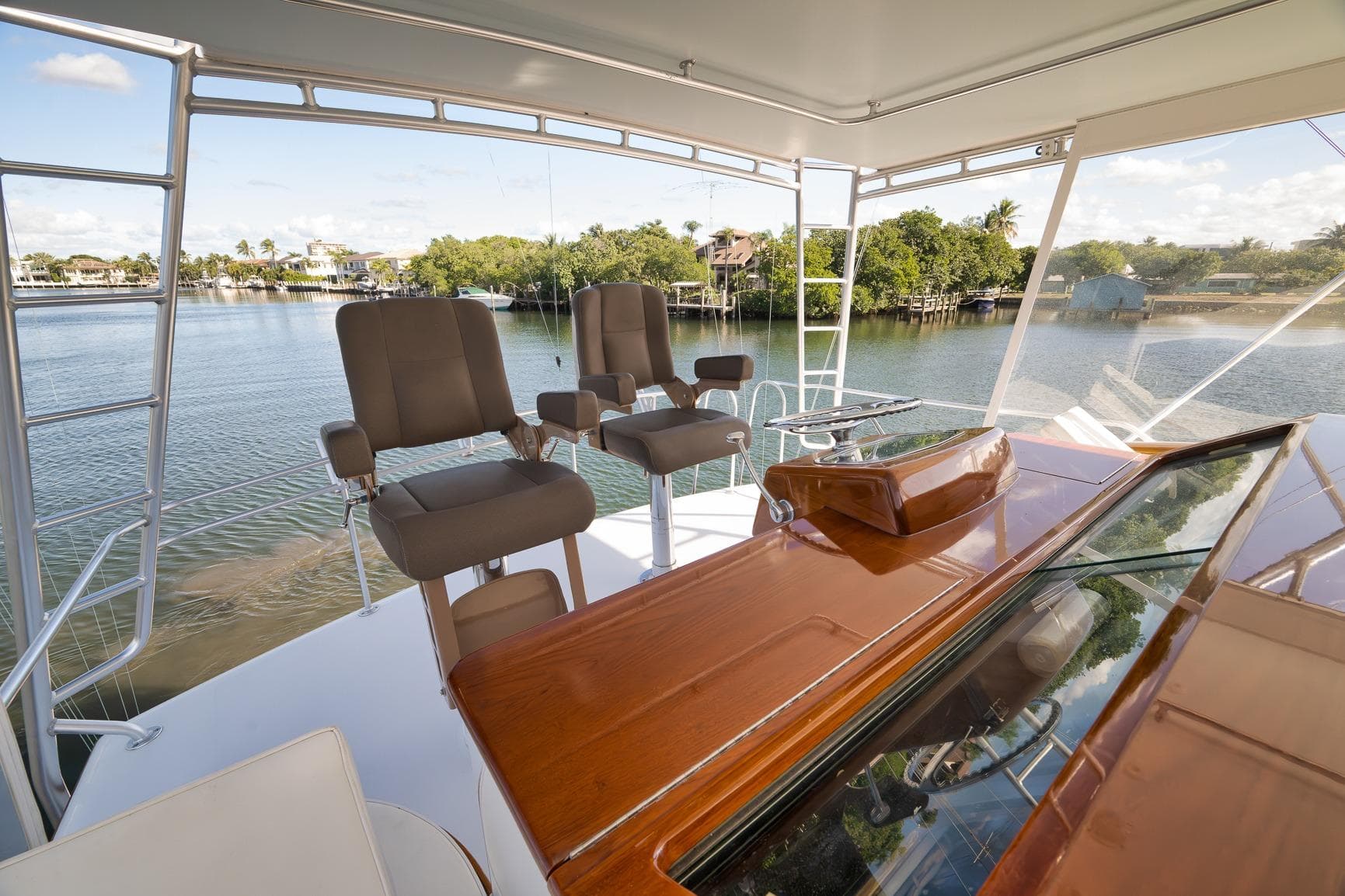 1993 Merritt Sportfish yacht helm with dual captain chairs overlooking serene waterfront.