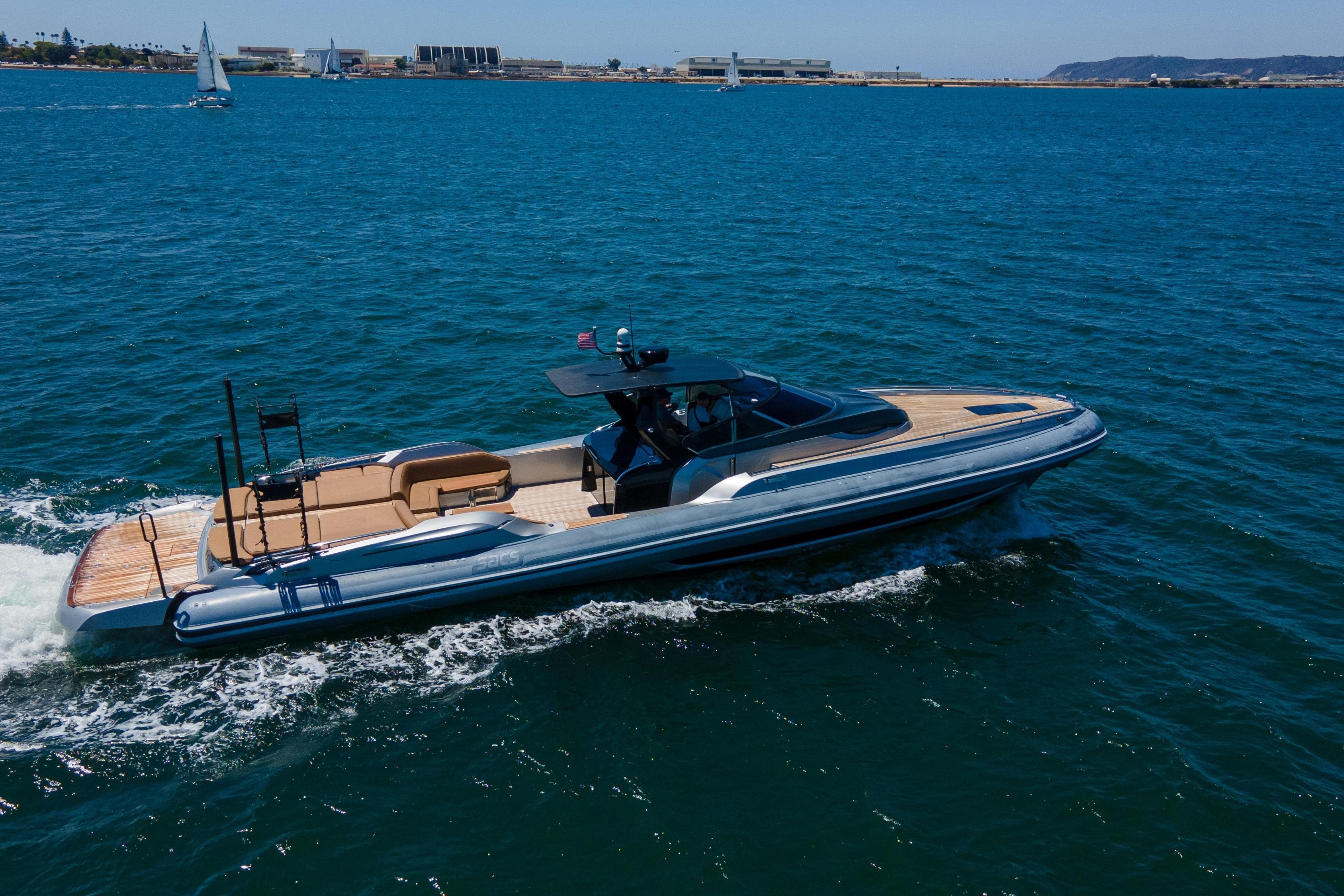 2014 SACS Strider yacht cruising on open water, with scenic coastal background.