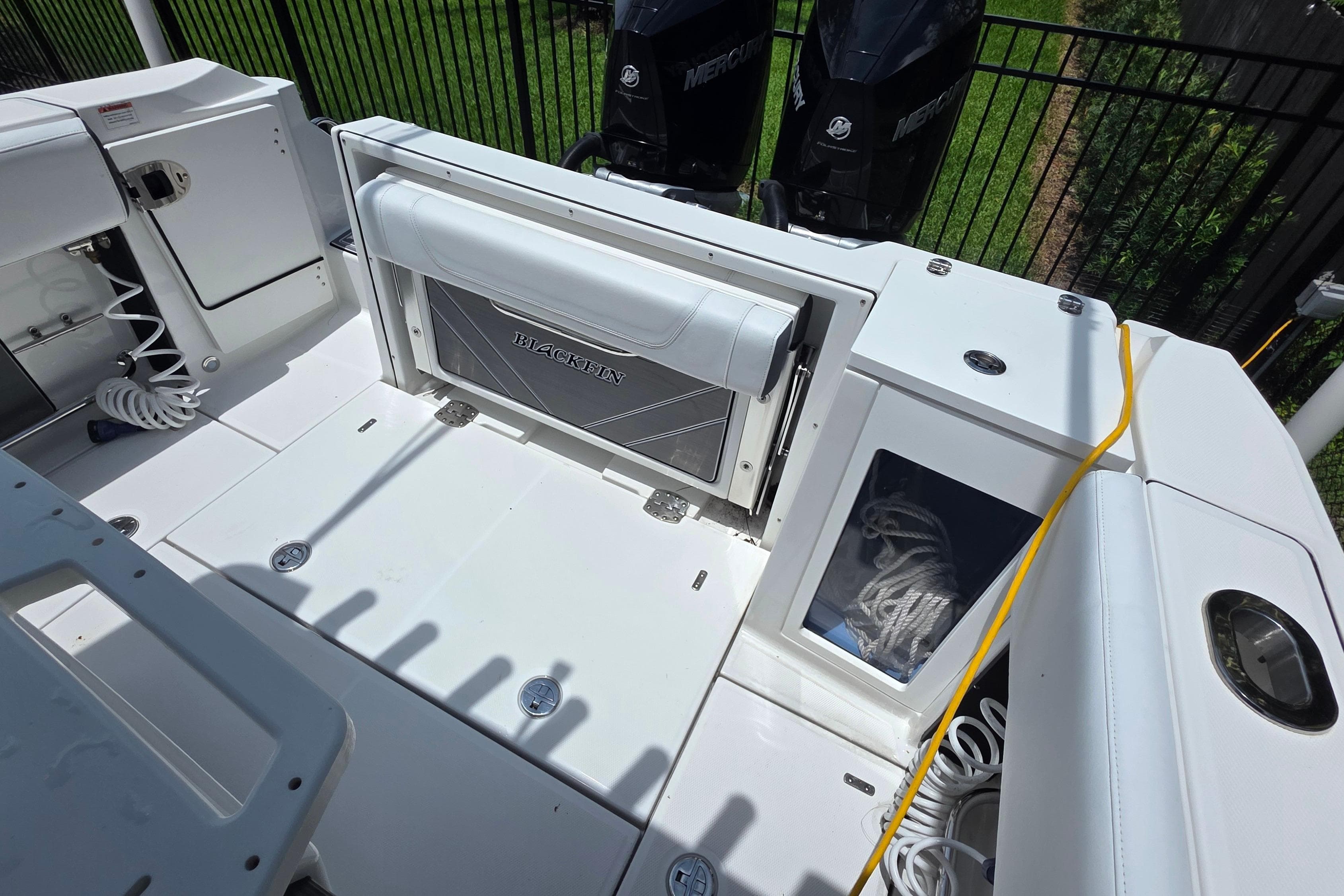 2021 Blackfin 272 CC boat deck with storage compartments and dual Mercury engines.