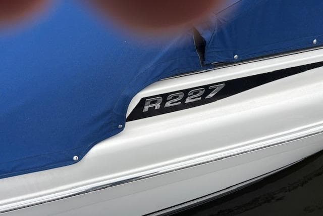 2017 Robalo R227 Dual Console boat with blue cover on water.