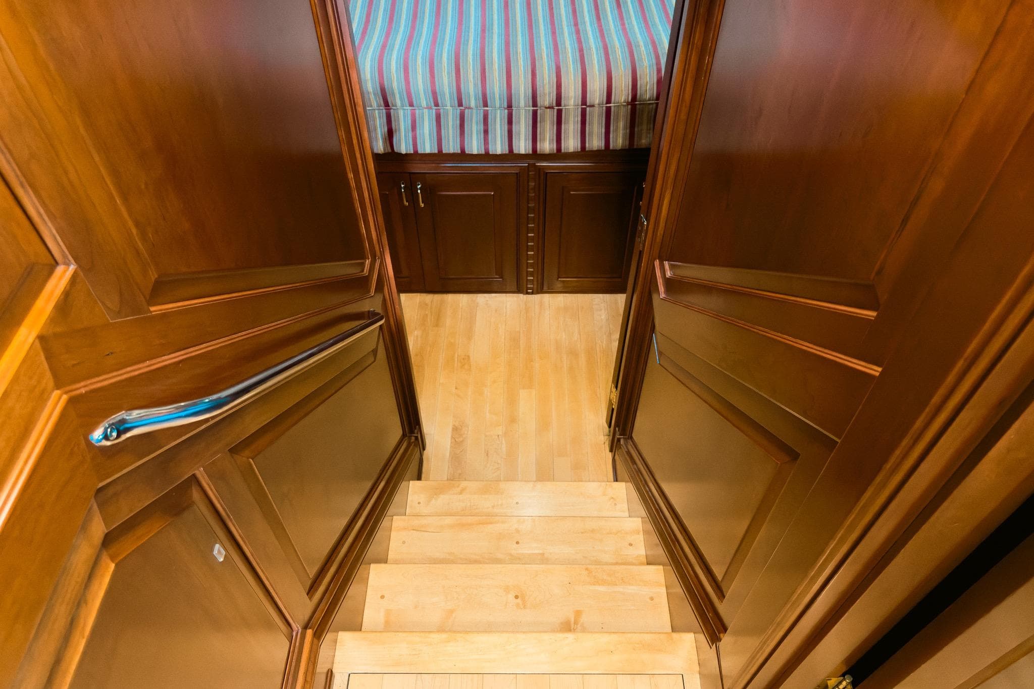 Staircase leading to a cozy cabin with wooden interior on a 2002 Darling Yachts Custom Aluminum.