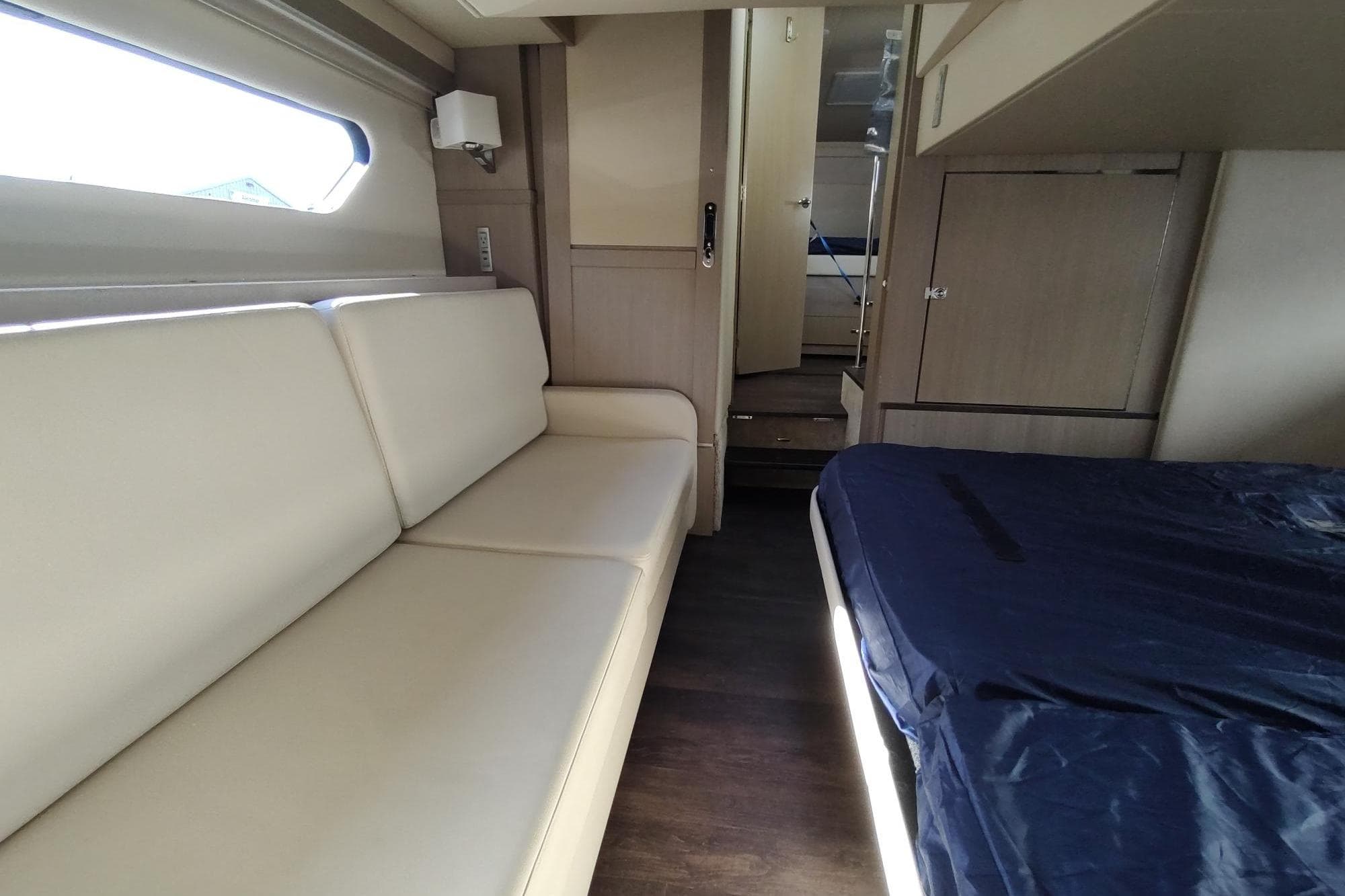 Interior of 2021 Regal 42 Fly yacht with beige seating and bed.