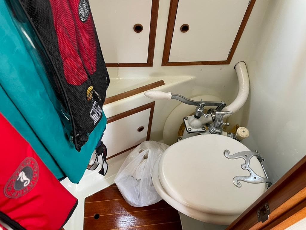 1973 Camper & Nicholsons 38 yacht bathroom with compact toilet and storage cabinets.