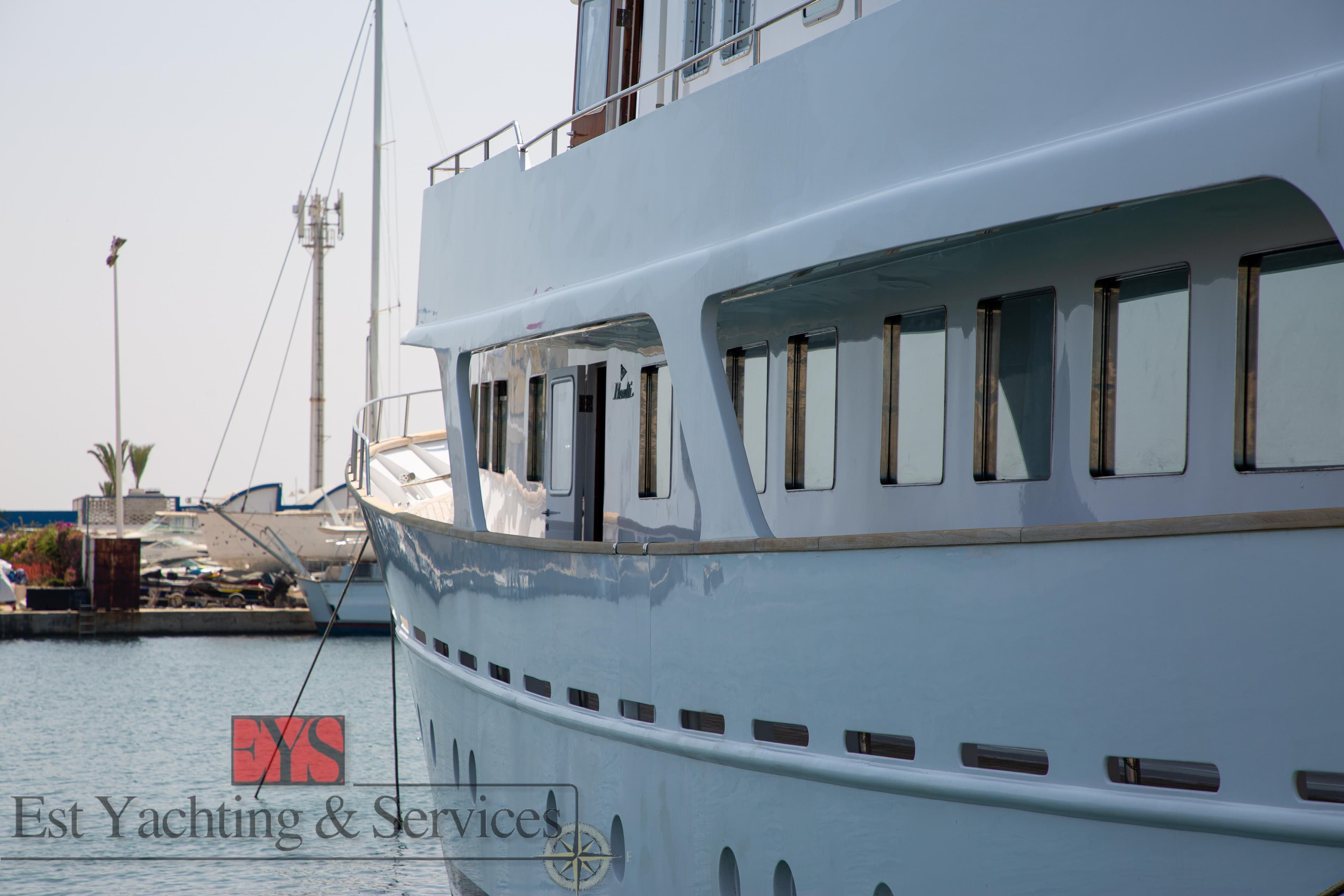 Benetti 33 yacht from 1972 docked at a marina, showcasing sleek design and windows.