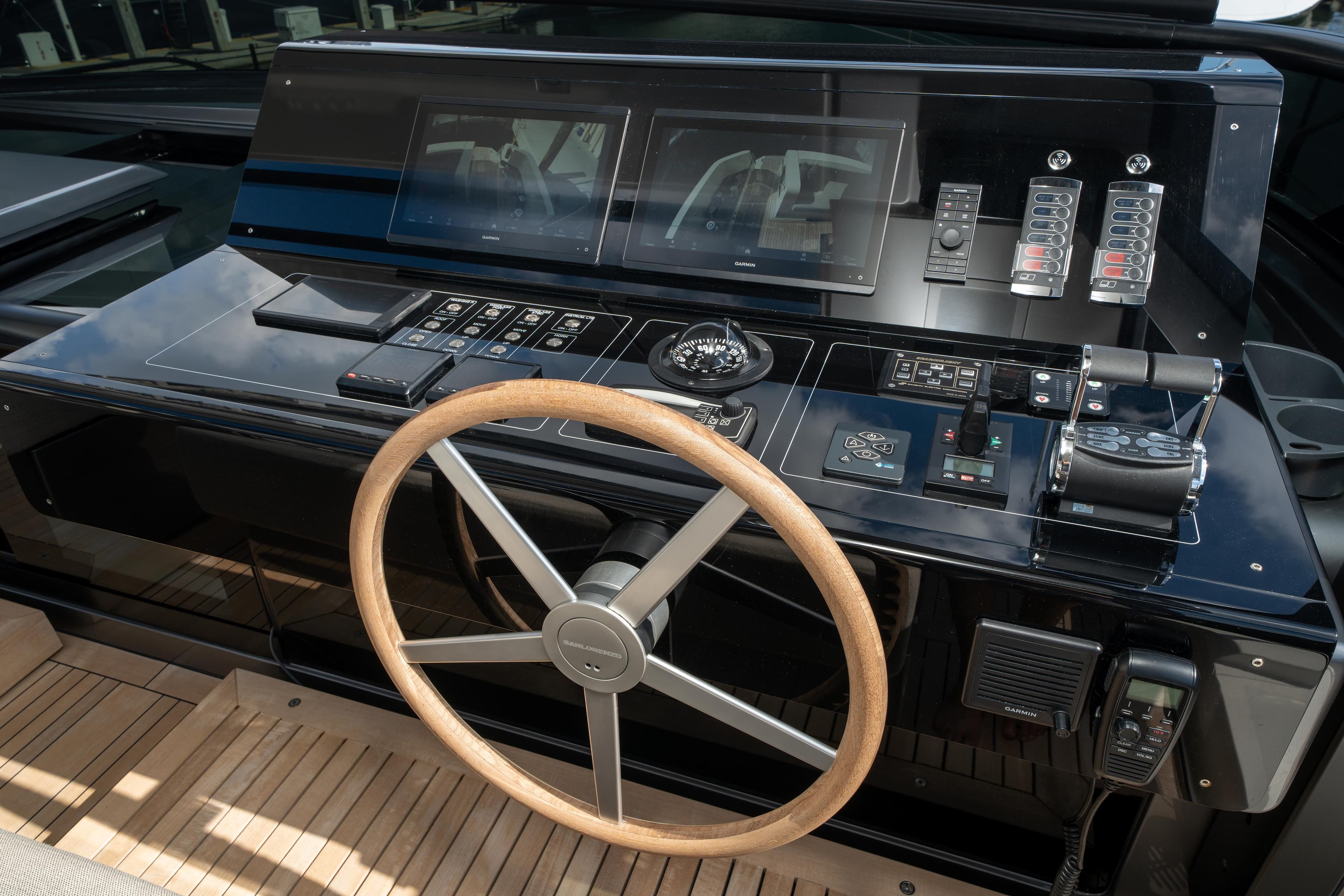 2022 Sanlorenzo SL96A yacht helm with modern controls and wooden steering wheel.