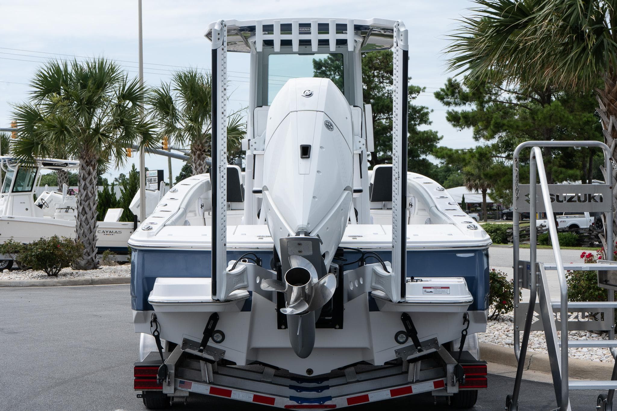 2026 Blackfin 262 HB boat on trailer, rear view, with palm trees in background.