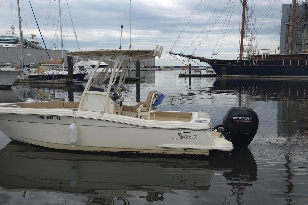 2023 Scout 215 XSF boat docked in a marina with Mercury outboard motor.