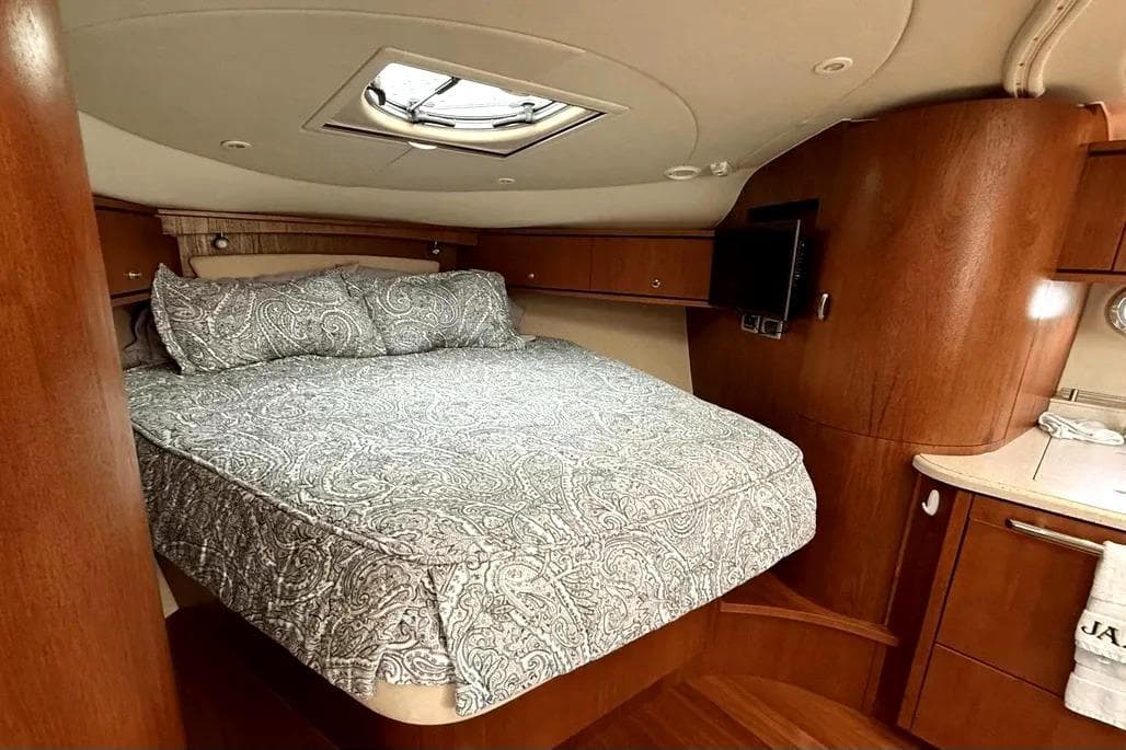 Luxurious cabin interior of 2008 Tiara 35 Sovran yacht with elegant bedding and wood finish.