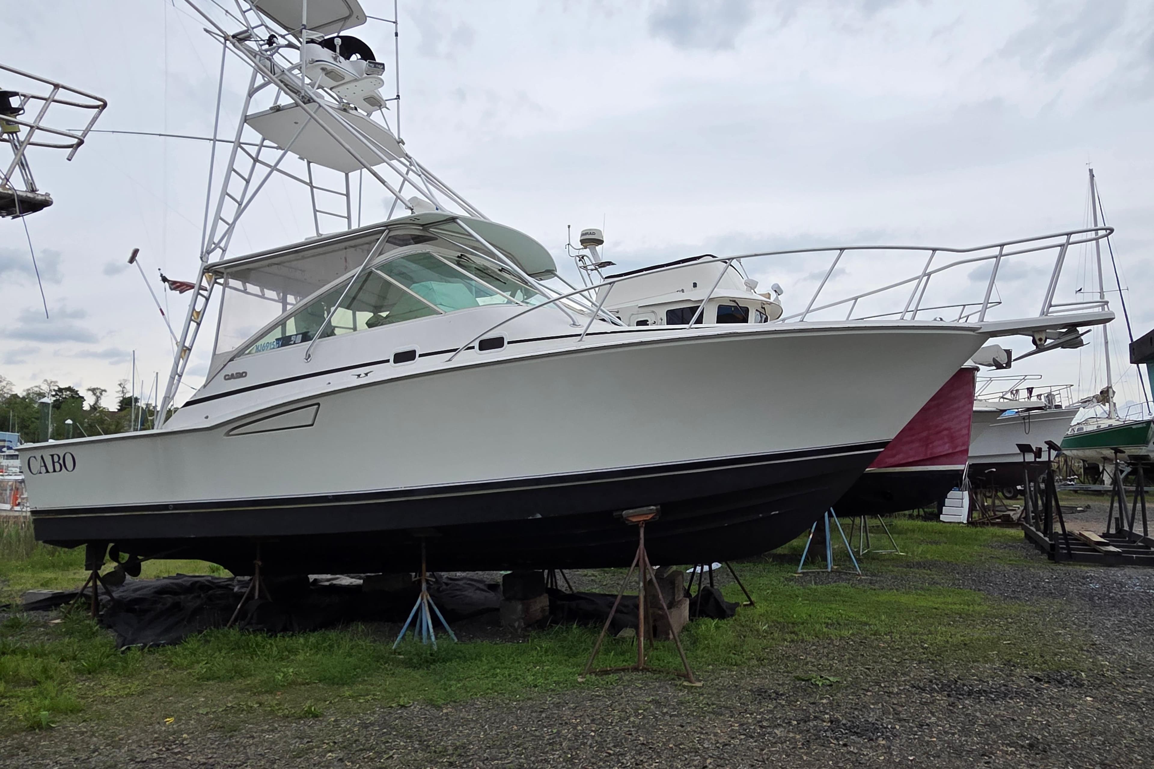 1999 Cabo 35 Express boat on stands, ready for maintenance or inspection.