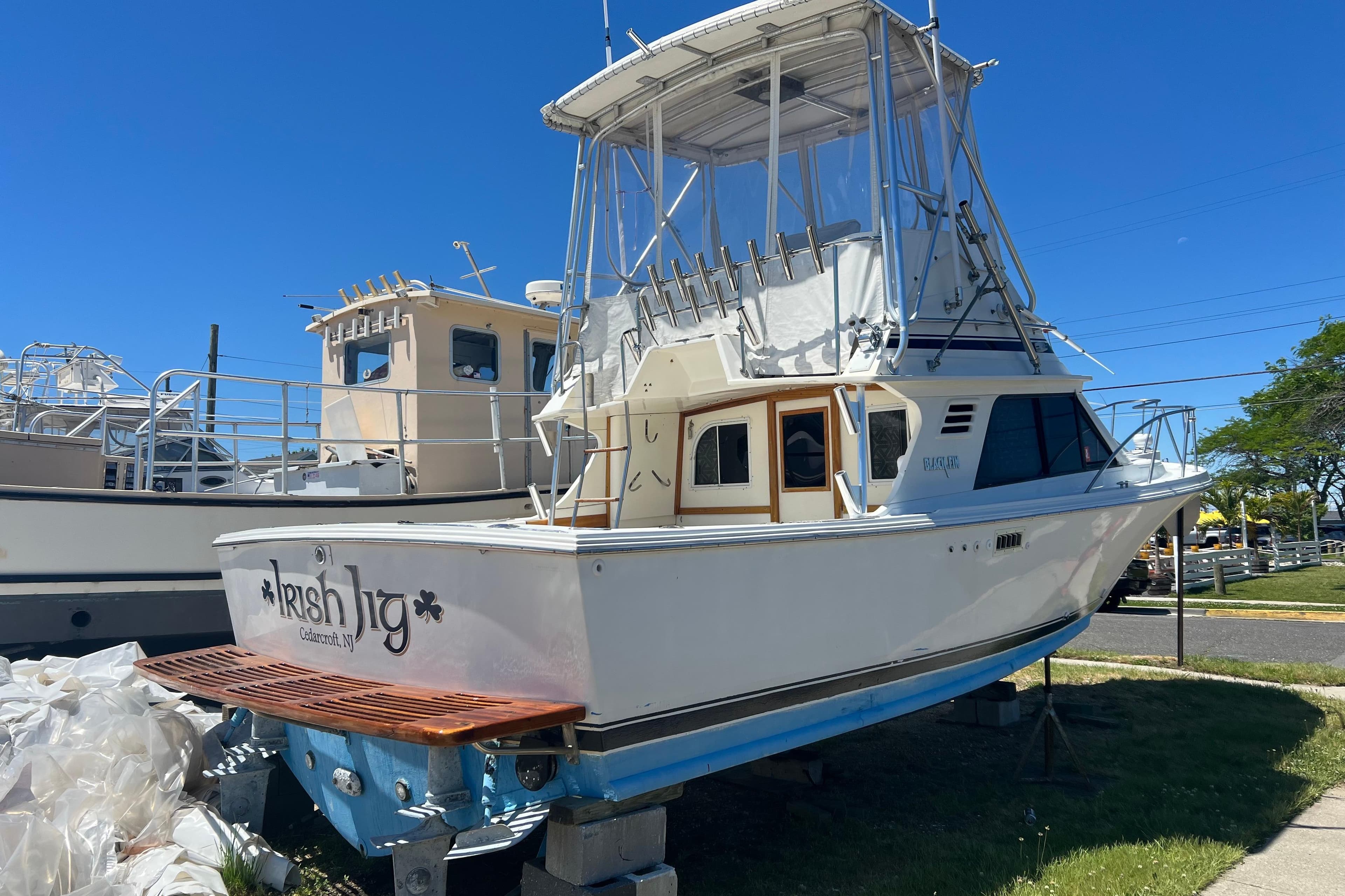 1988 Blackfin 29 Flybridge boat named "Irish Jig" on display in a marina.