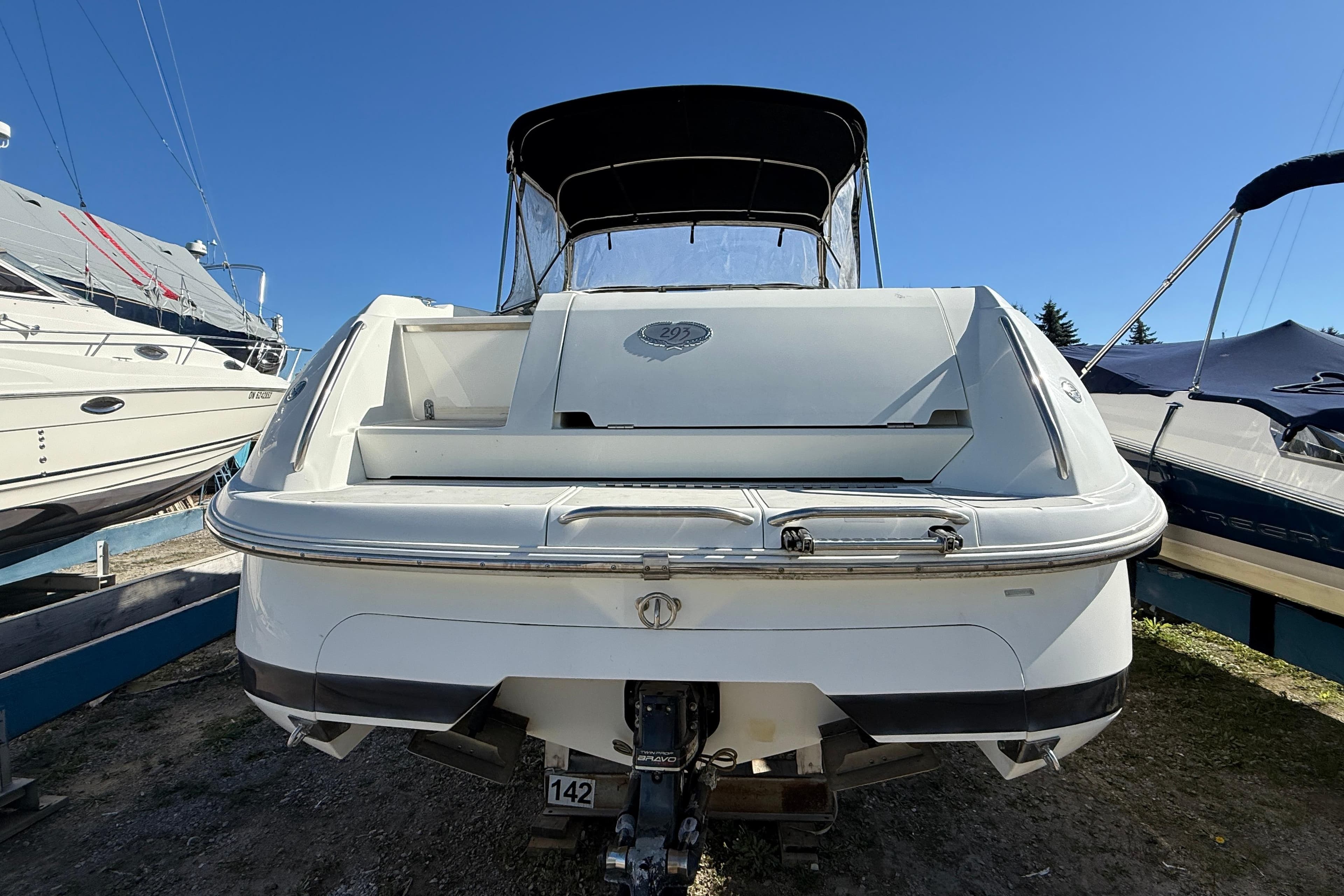 1997 Cobalt 293 boat, rear view, docked under clear blue sky.