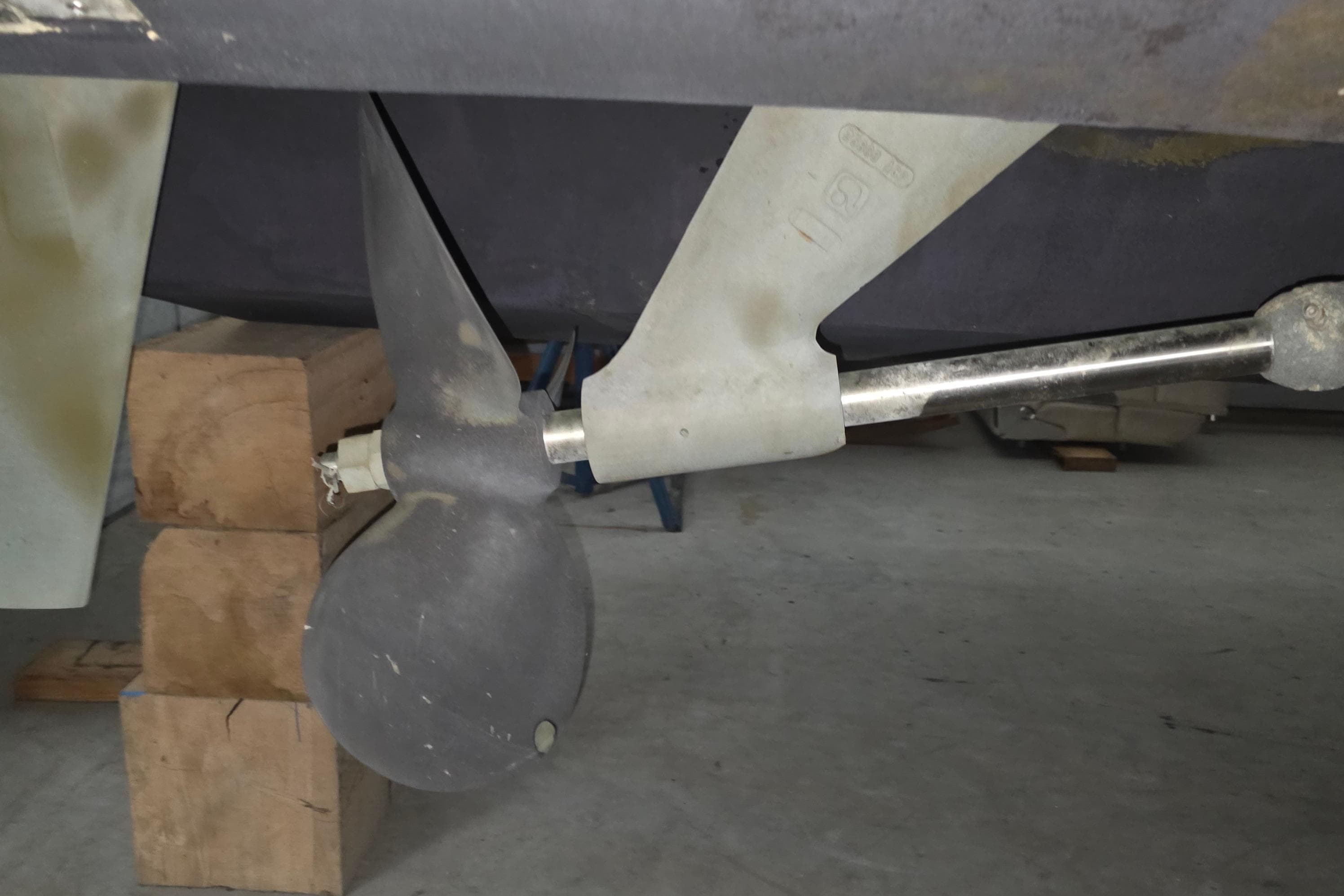 Propeller and shaft of a 2005 Tiara 290 Coronet boat in a workshop.