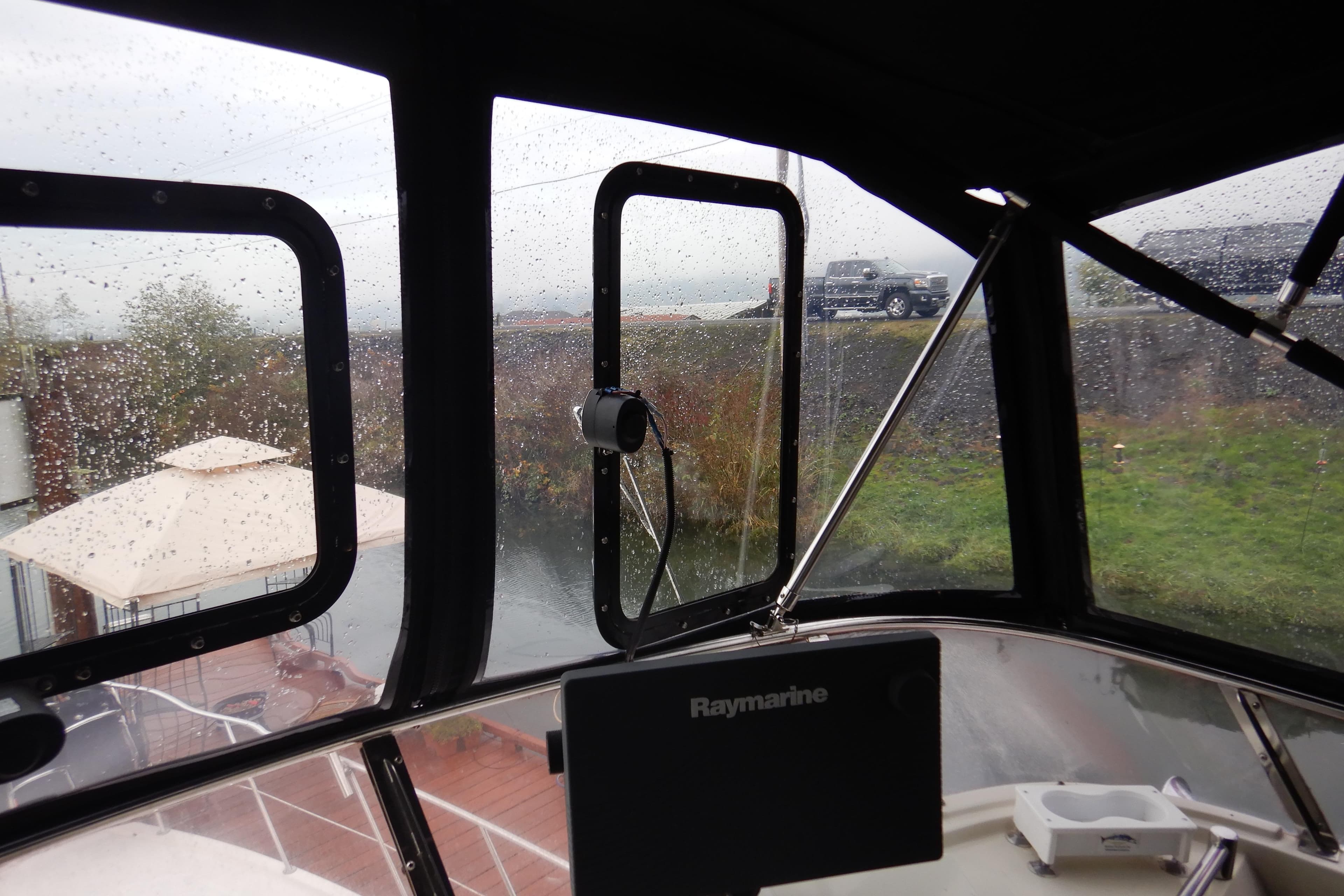 Interior view of 1988 Camargue 48 Cockpit Motor Yacht with rain-speckled windows.