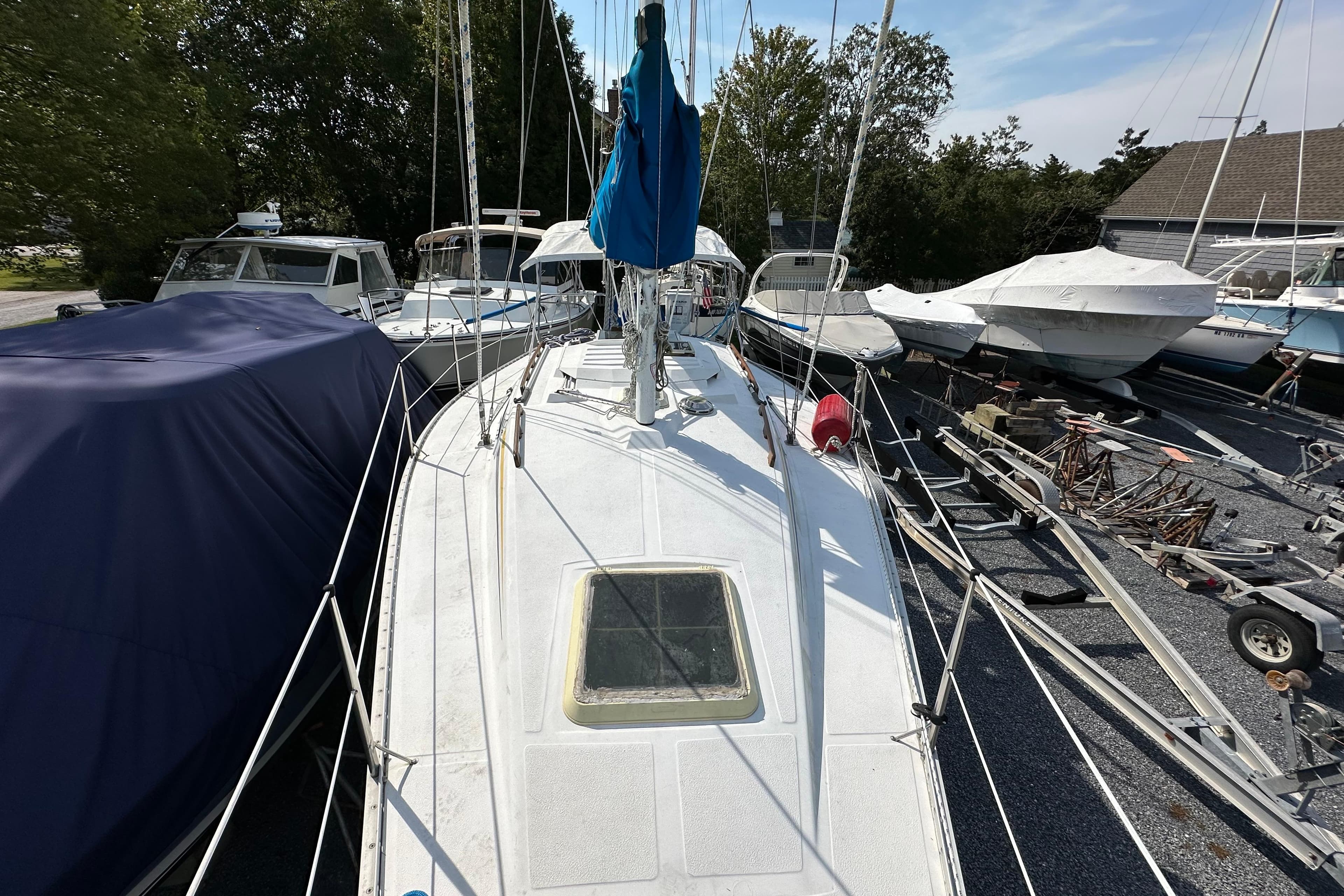 1985 Hunter 28.5 sailboat on land, surrounded by other boats and trailers.