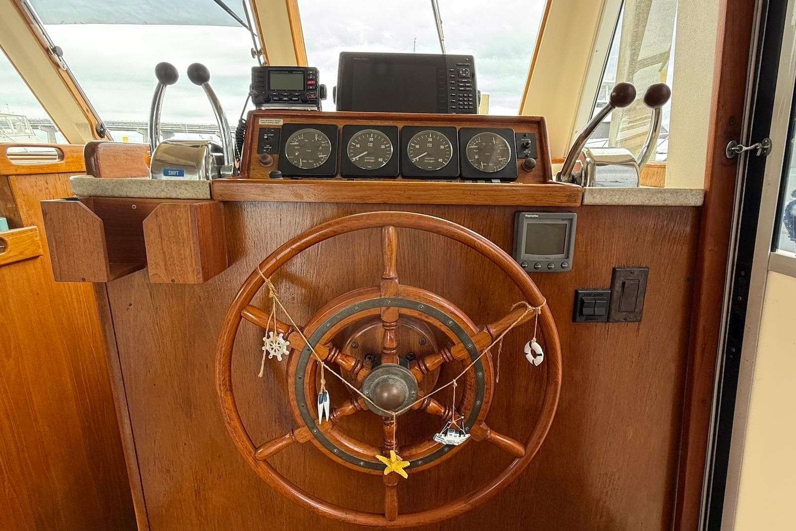 1998 Mainship 350 Trawler helm with wooden wheel and navigation instruments.
