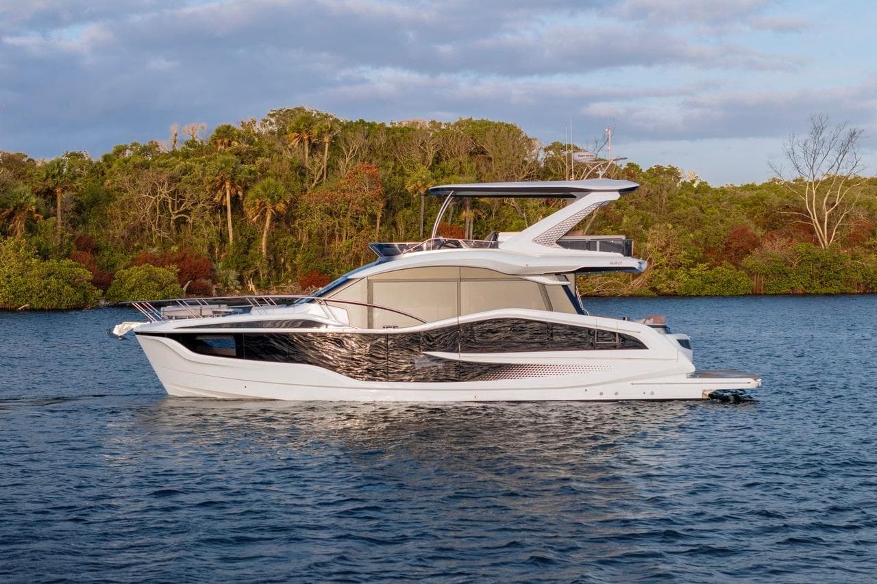 2026 Galeon 520 Fly yacht cruising on a serene lake with lush greenery.