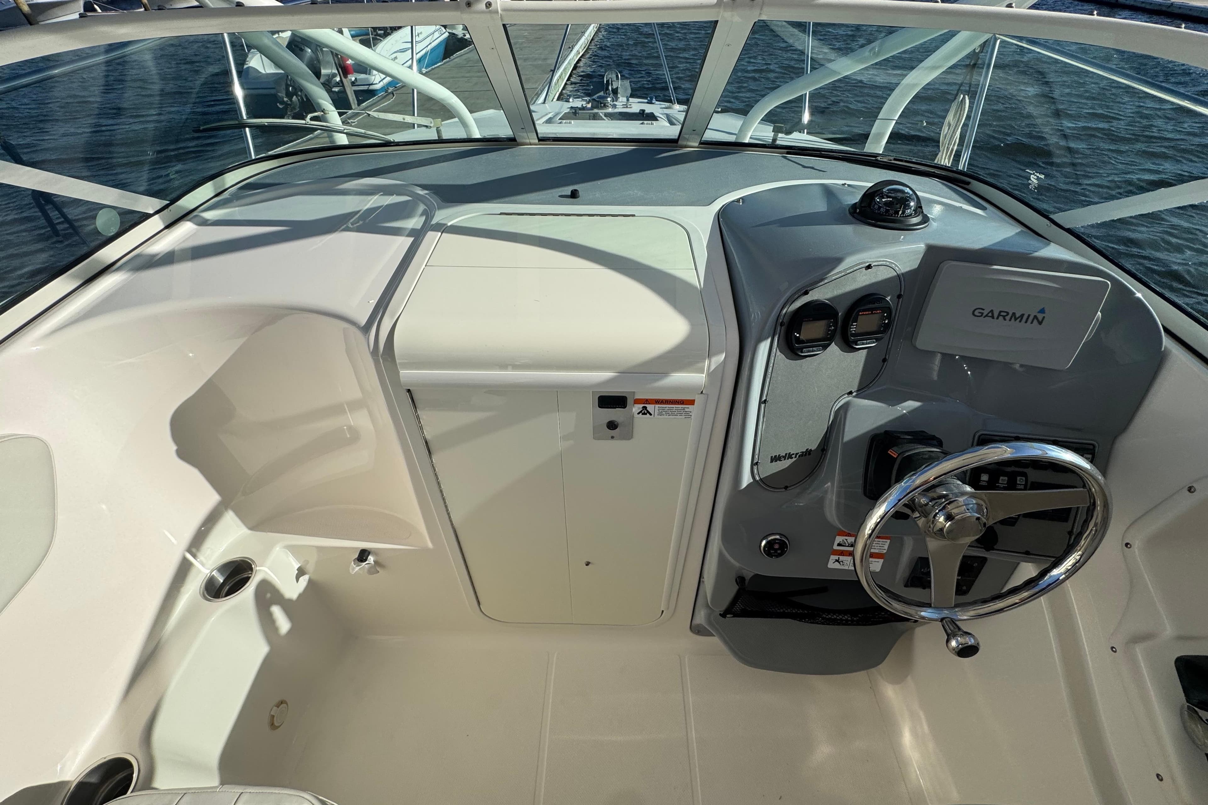 2014 Wellcraft 252 Coastal boat cockpit with Garmin navigation system and steering wheel.
