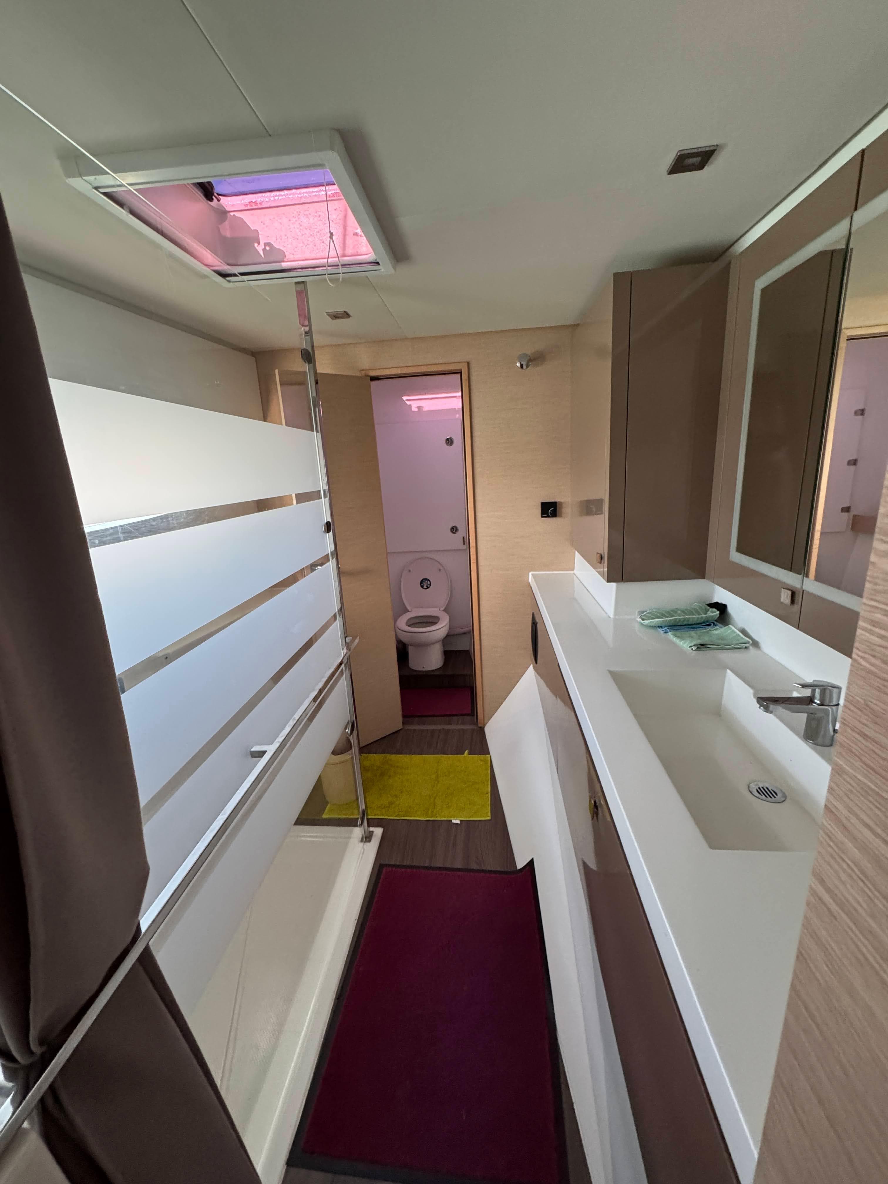 Modern bathroom interior of 2019 Fountaine Pajot Saona 47 catamaran, featuring sleek design and amenities.