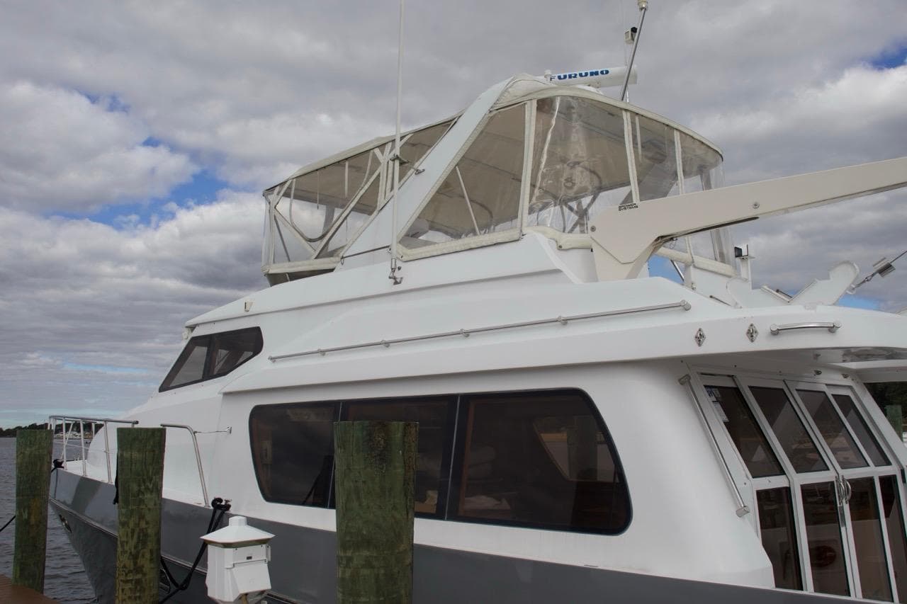 2002 McKinna 57 Pilothouse yacht docked under cloudy skies.