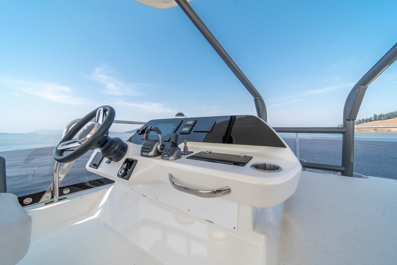 Helm of 2025 Prestige F4.9 yacht with modern controls and ocean view.