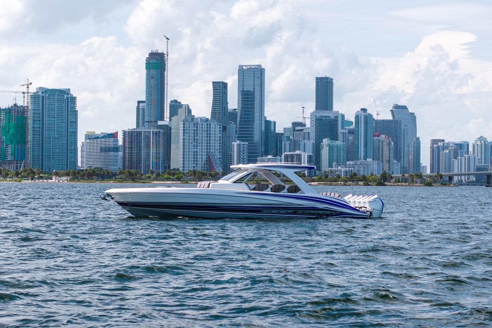 Deep Impact 449 Sport boat cruising near a city skyline, 2027 model.