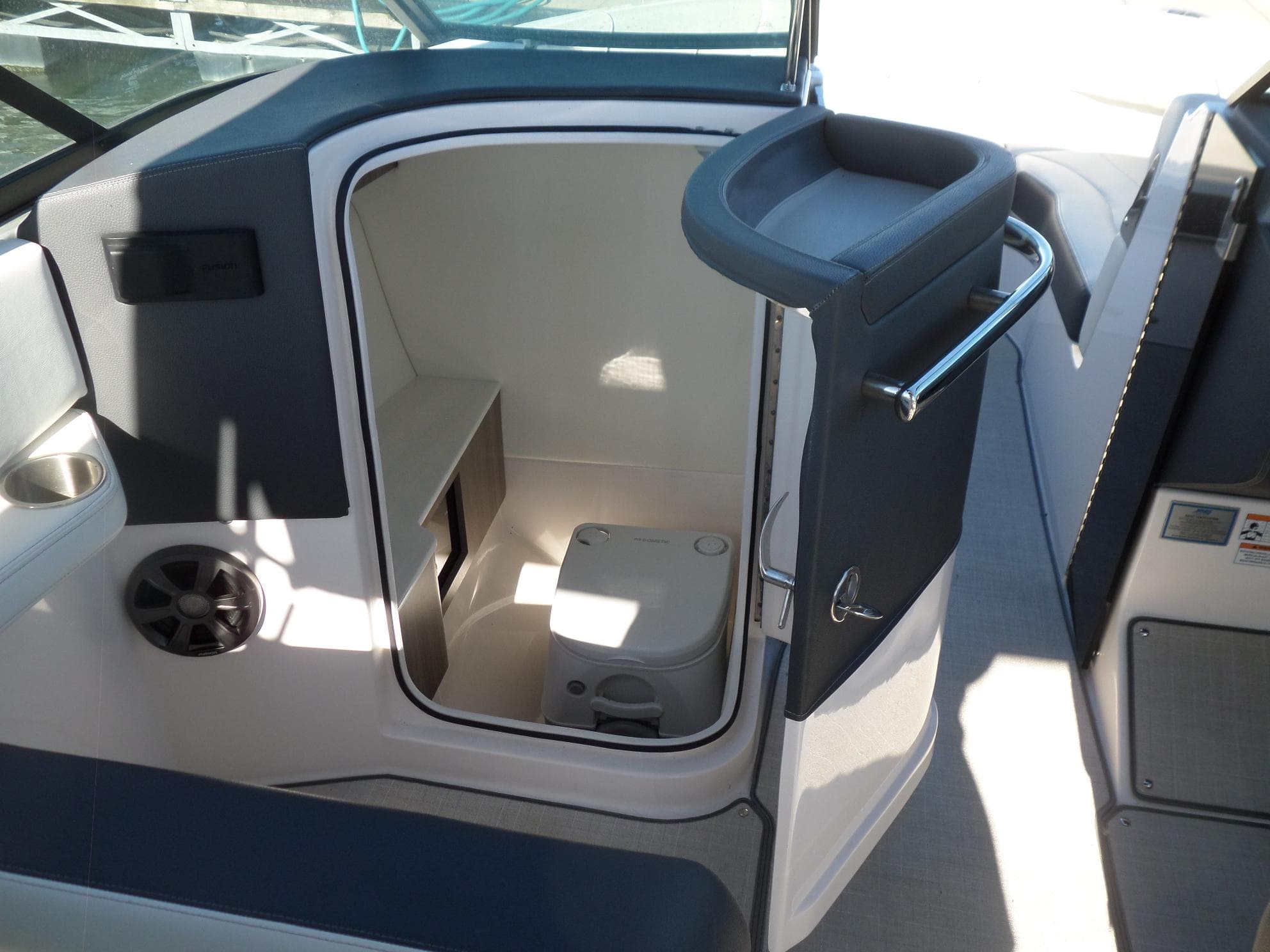 2020 Regal LS6 boat interior with compact marine toilet and seating area.