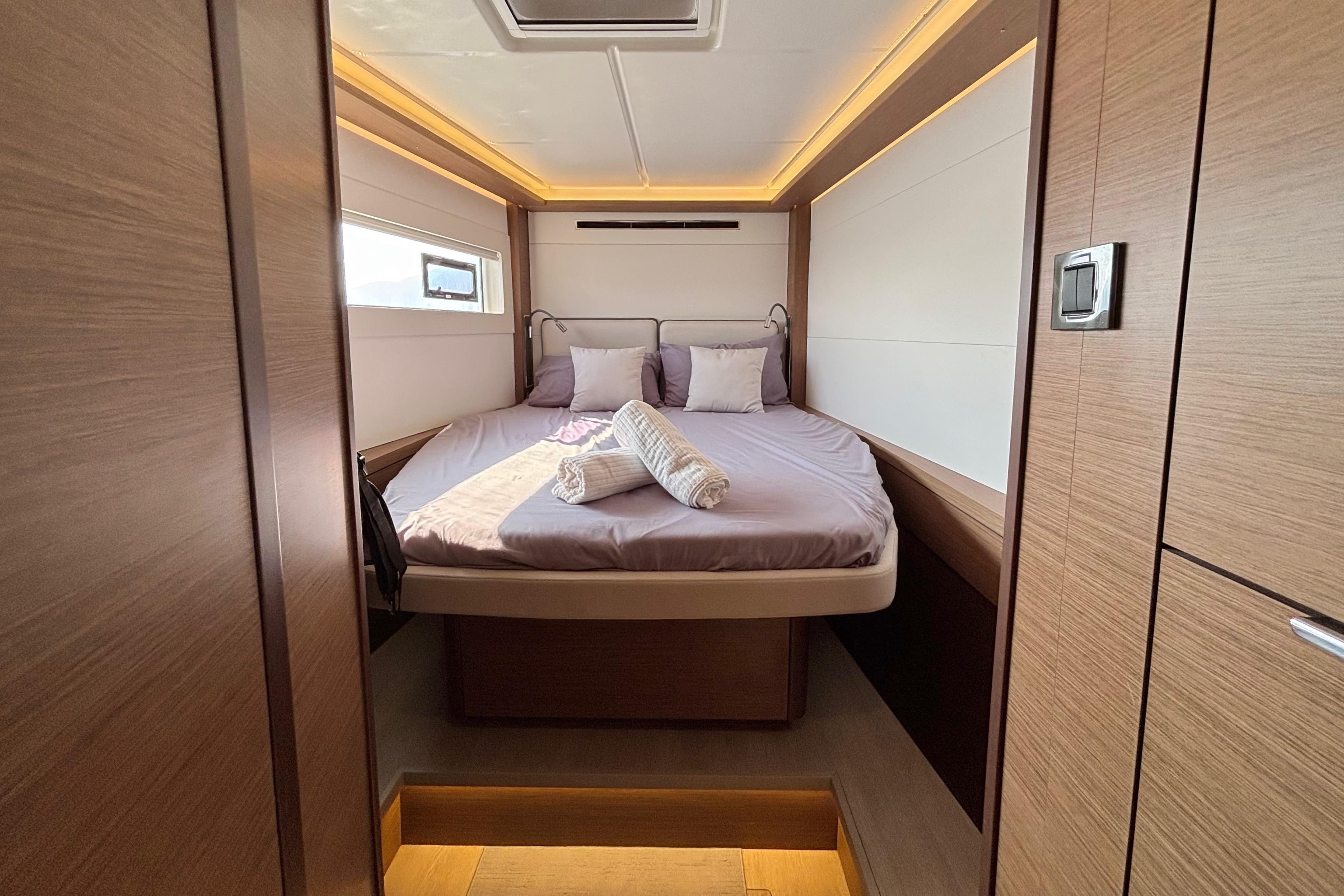 Luxurious cabin interior of 2020 Lagoon 46 yacht with cozy bed and modern design.