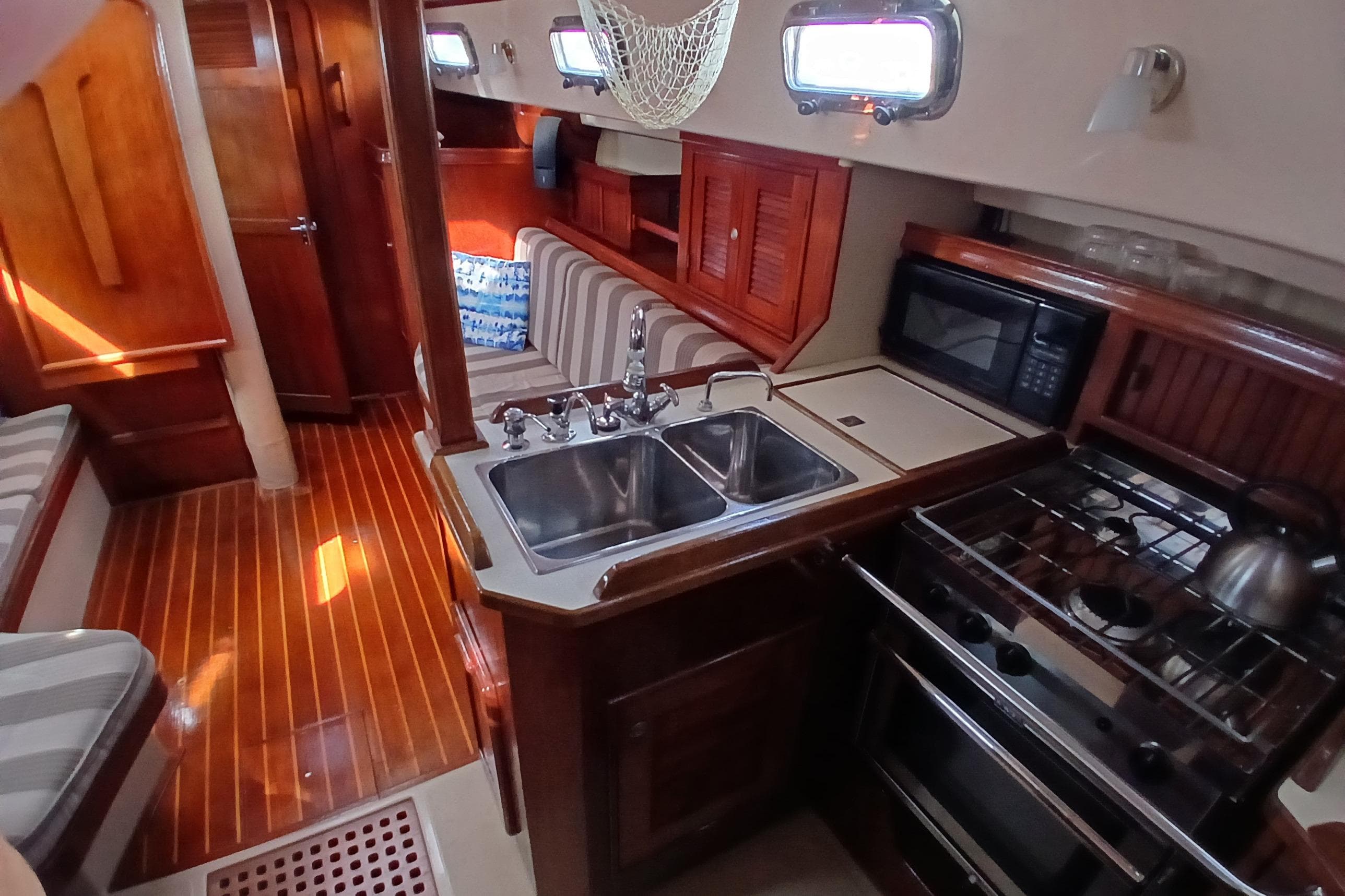 Interior of a 1995 Island Packet 37 sailboat with kitchen and seating area.