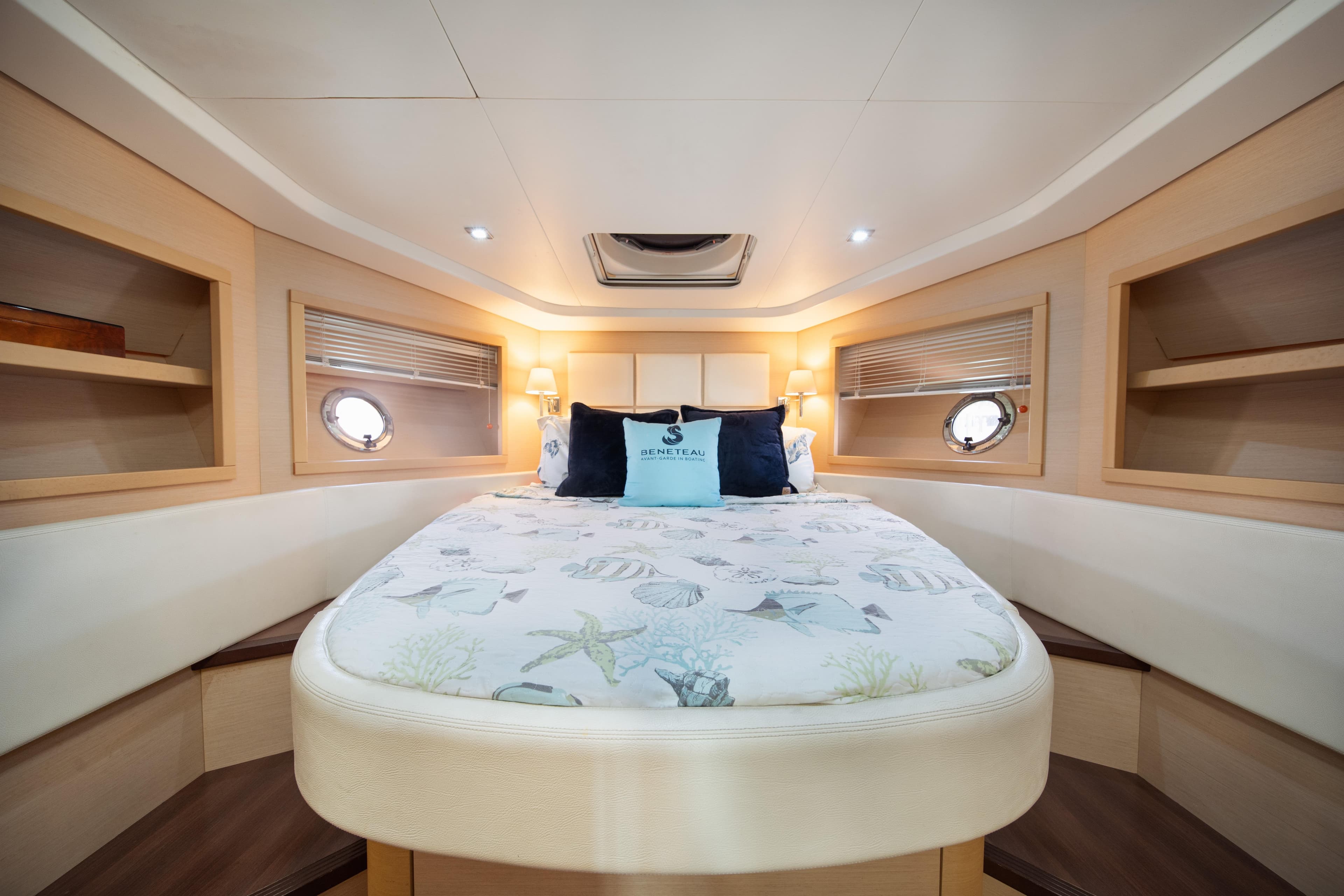 Luxurious cabin interior of 2010 Beneteau Monte Carlo 47 yacht, featuring elegant bedding and portholes.