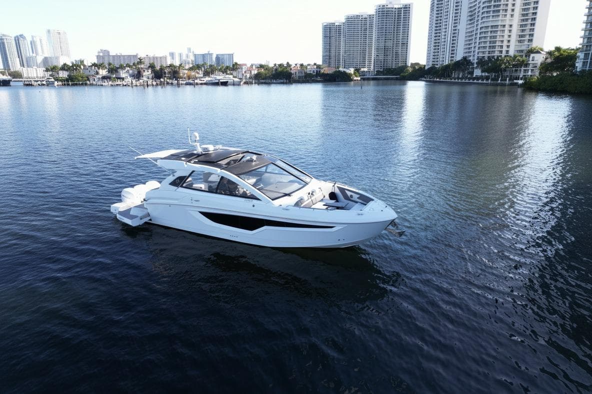 2021 Cruisers Yachts 42 GLS OB on calm water near city skyline.