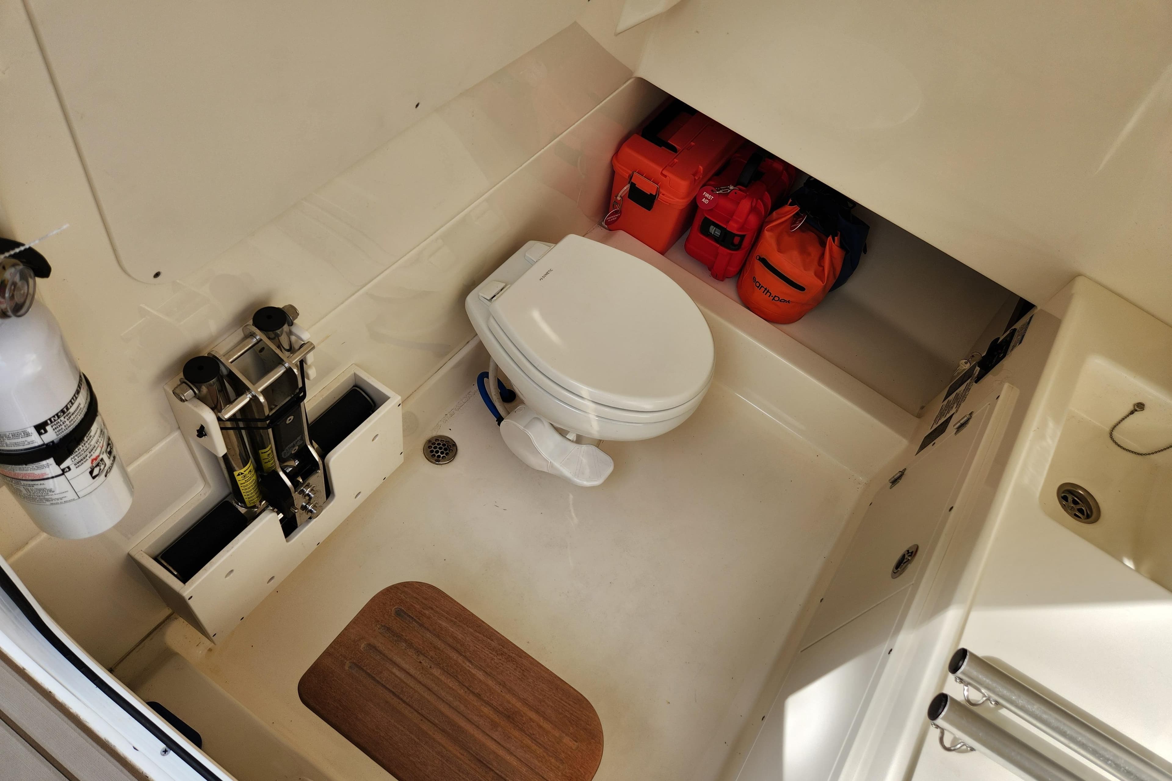 2022 Boston Whaler 330 Outrage cabin interior with toilet and safety equipment.