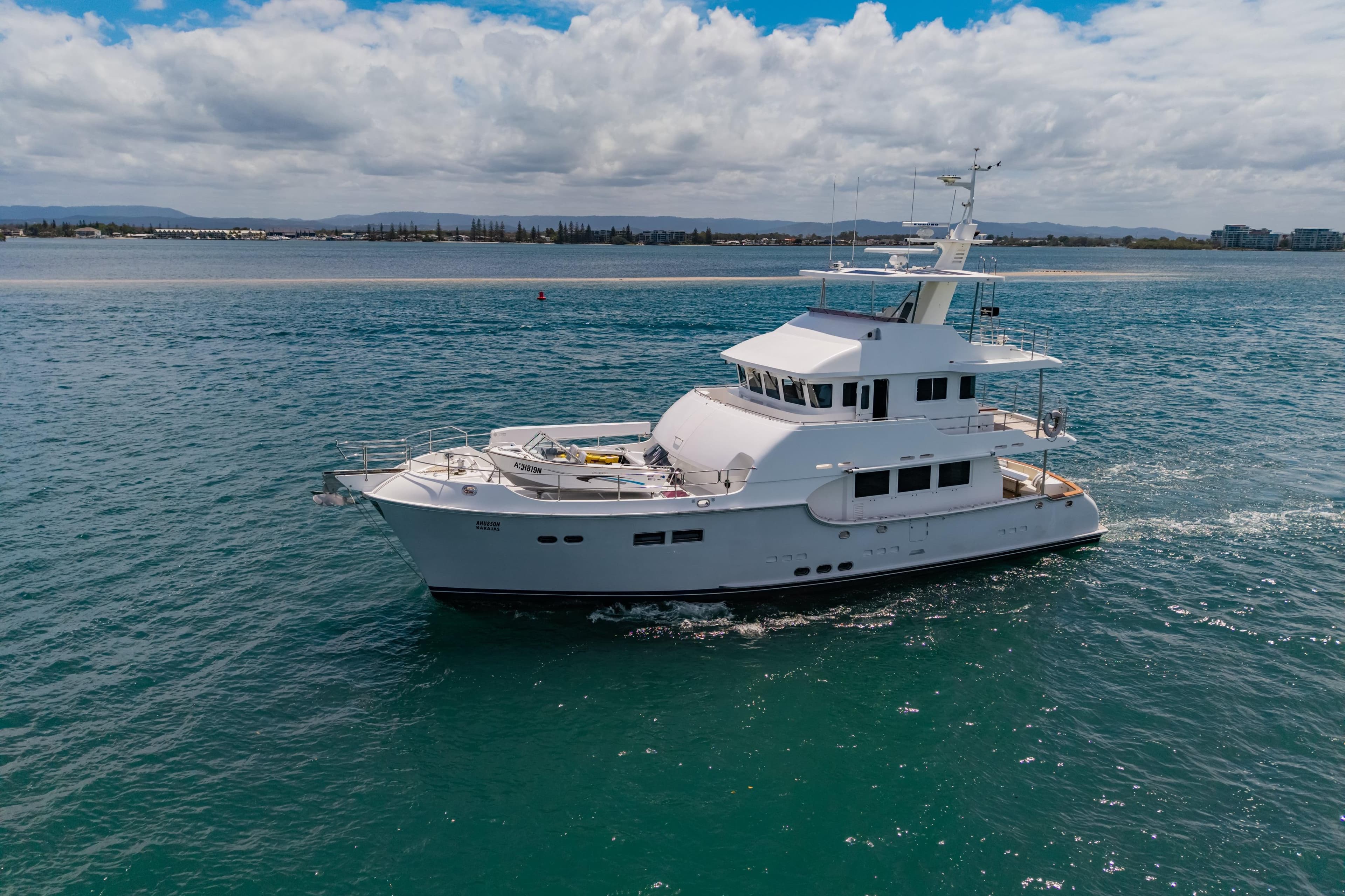 2013 Nordhavn 68 yacht cruising on open water under a partly cloudy sky.
