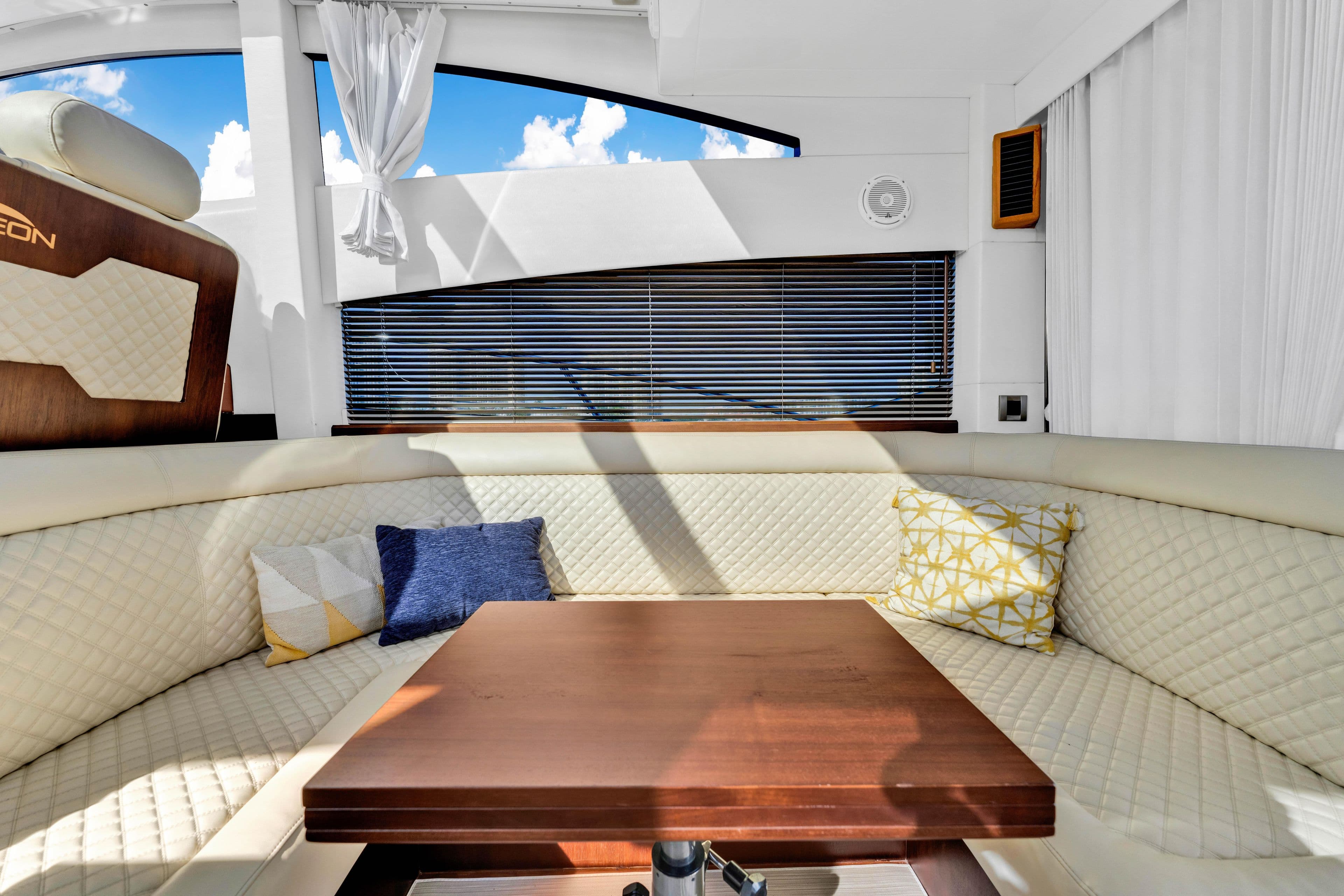 Luxurious interior of 2016 Galeon 430 HTC yacht with plush seating and wooden table.