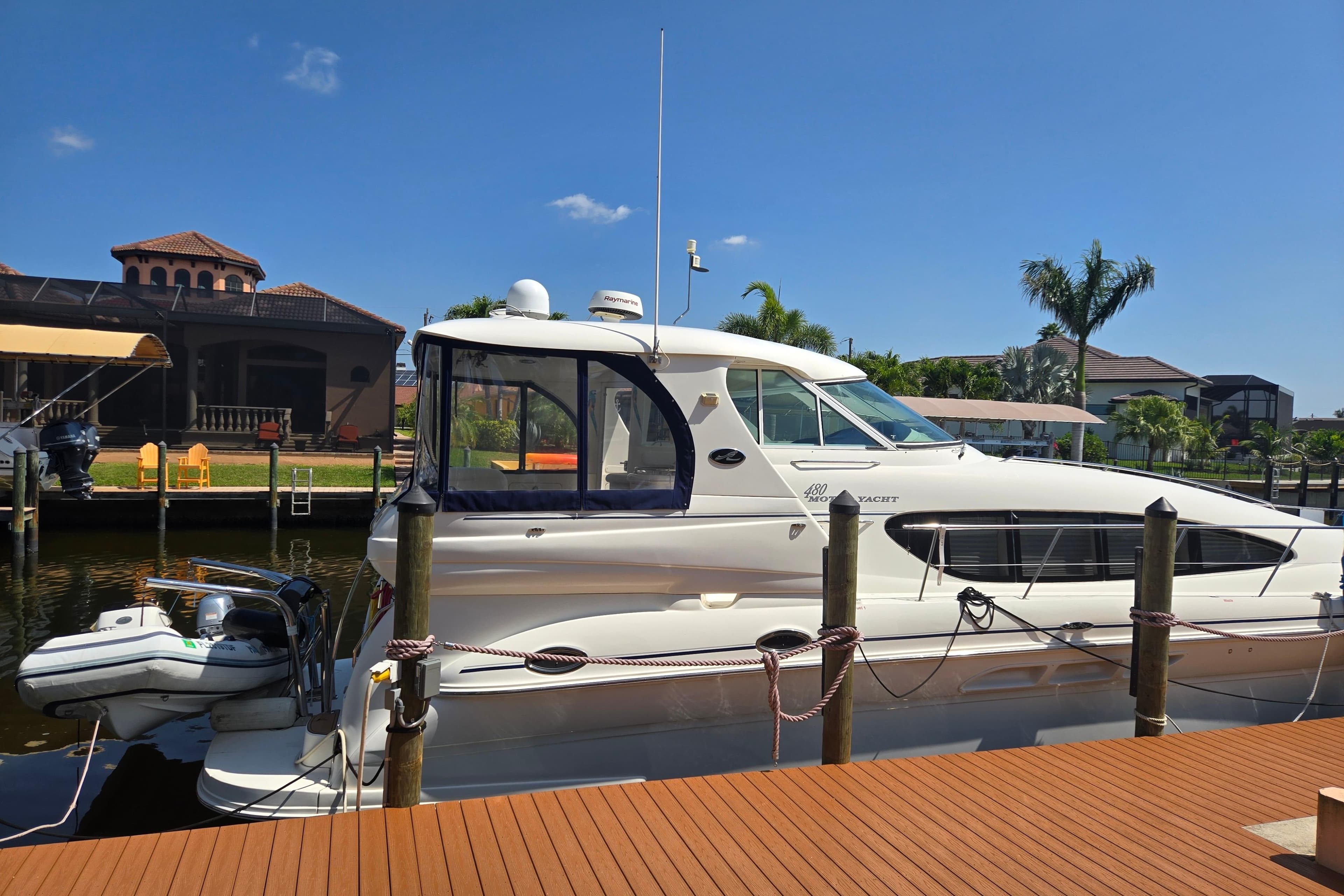 2004 Sea Ray 480 Motor Yacht docked at a sunny marina with palm trees.