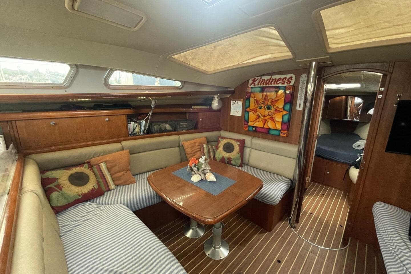 Interior of 2004 Hunter 44 sailboat with cozy seating and decorative pillows.