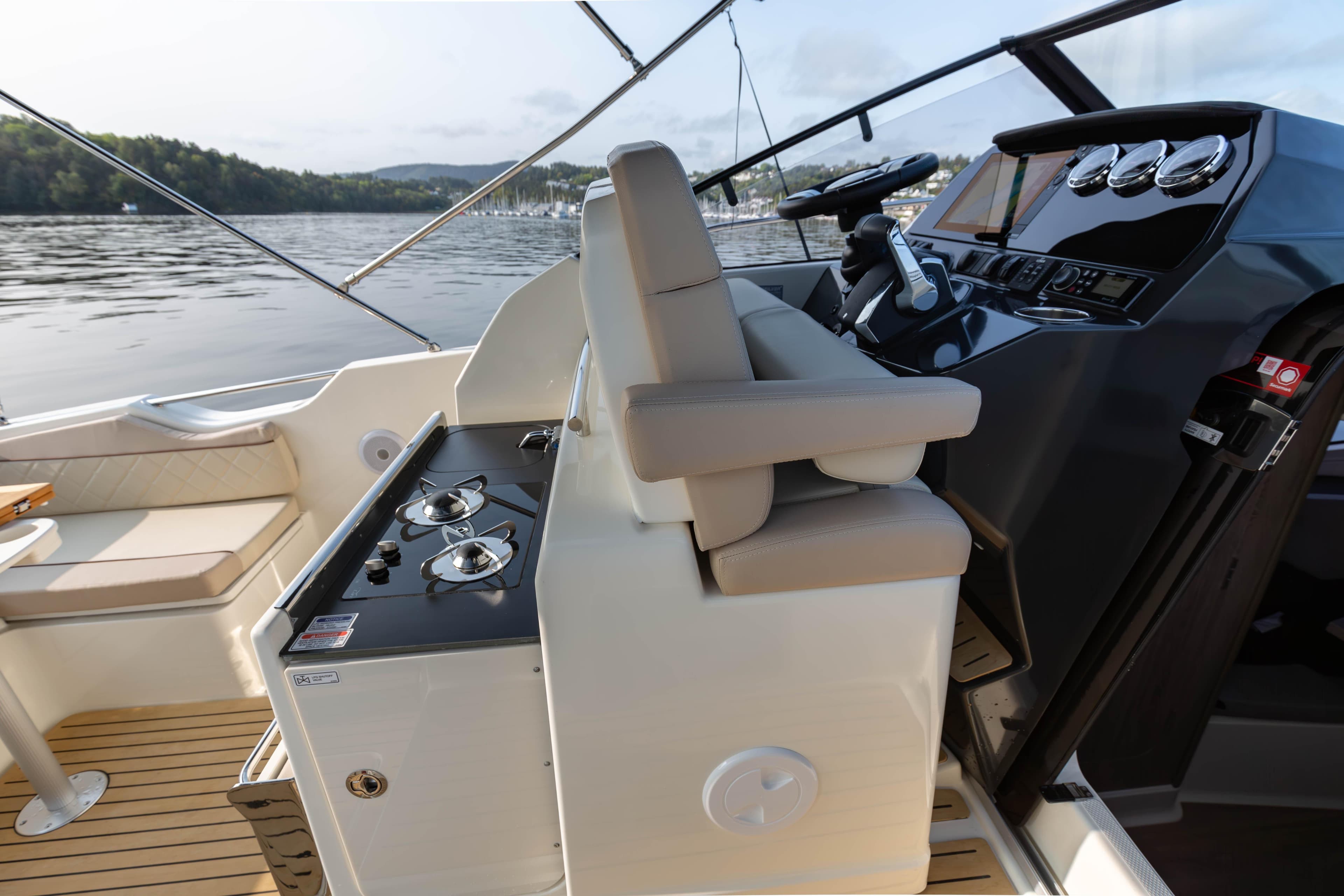 2024 Quicksilver Activ 875 Sundeck interior with helm and seating area.