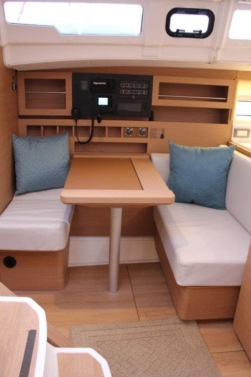 2024 Jeanneau Sun Odyssey 490 interior with cozy seating and modern navigation equipment.