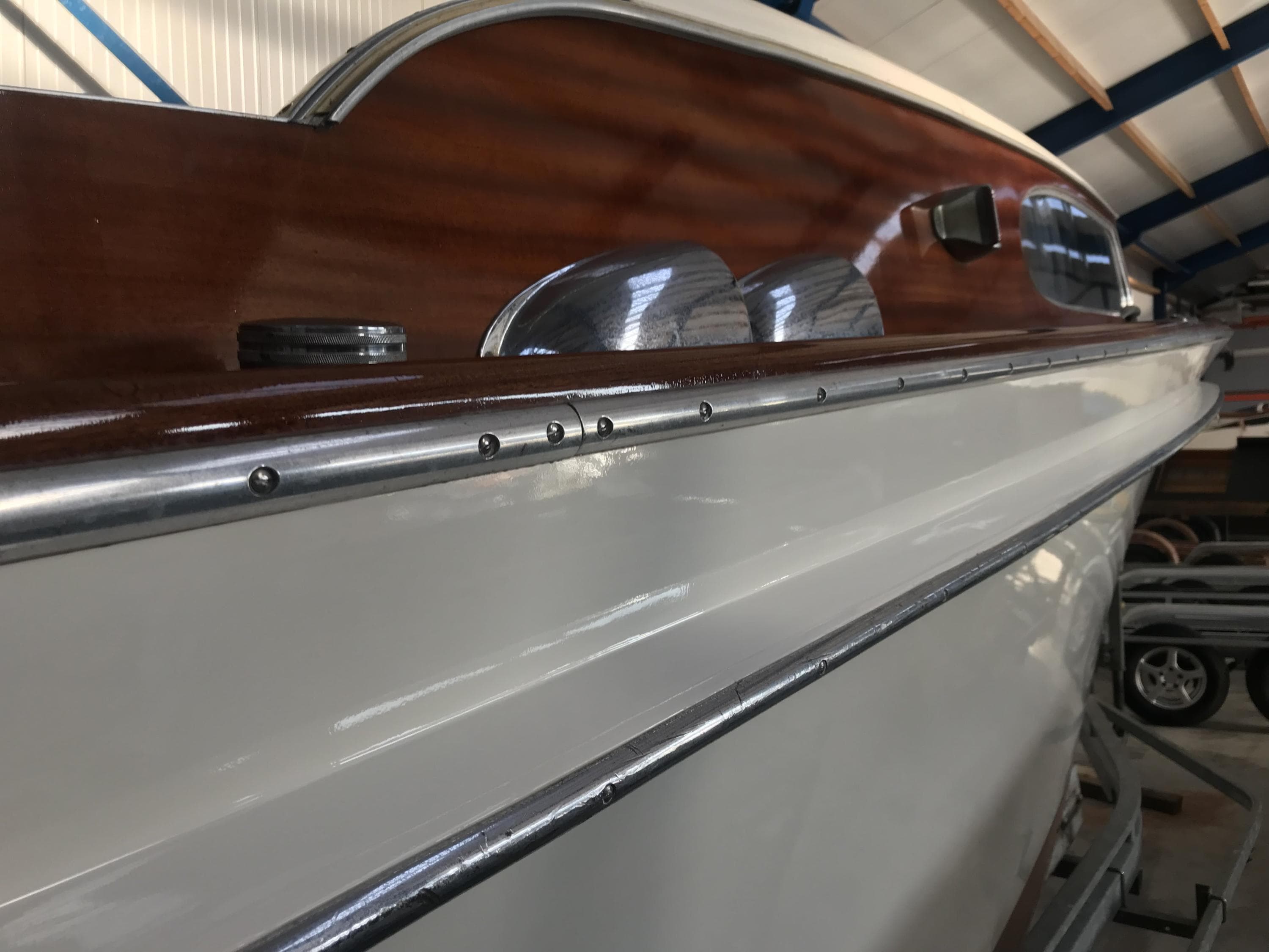 1962 Swiss Craft 820 boat with polished wood and sleek white exterior.
