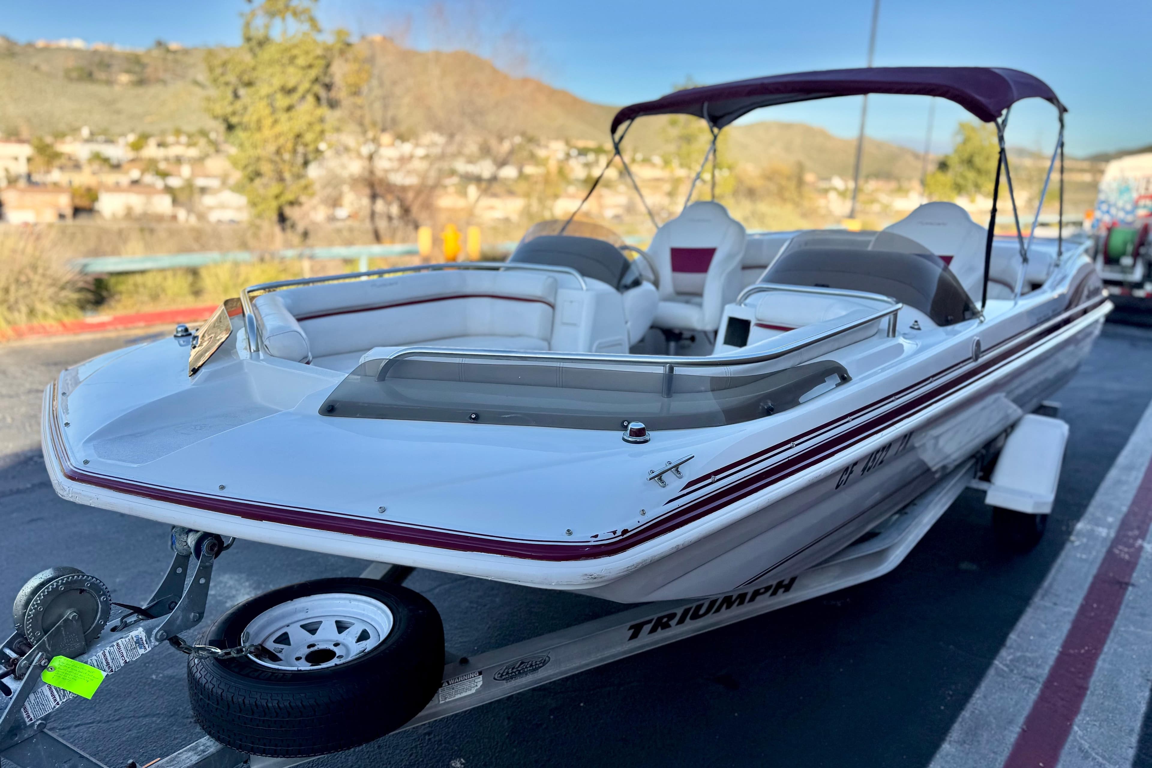 2000 Godfrey Hurricane 2100 Sundeck boat on trailer, parked outdoors.