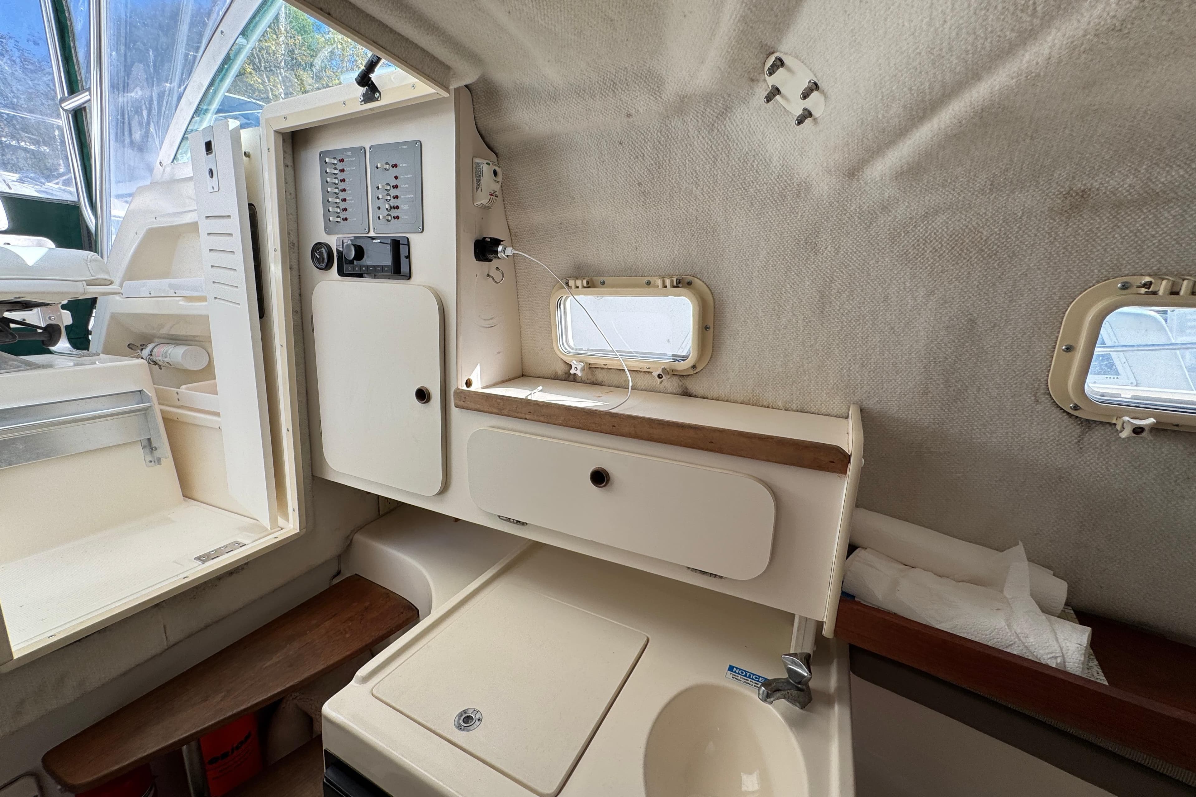Interior of a 1998 Pursuit 2800 Walkaround boat with control panel and sink.
