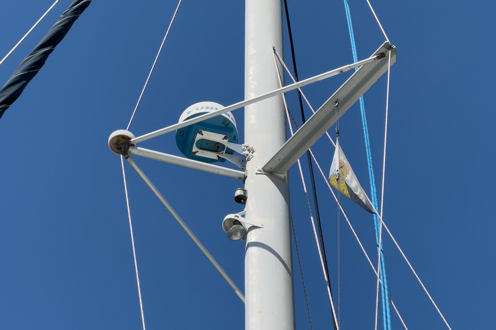 Mast of 2004 Lagoon 380 sailboat with radar and rigging against blue sky.